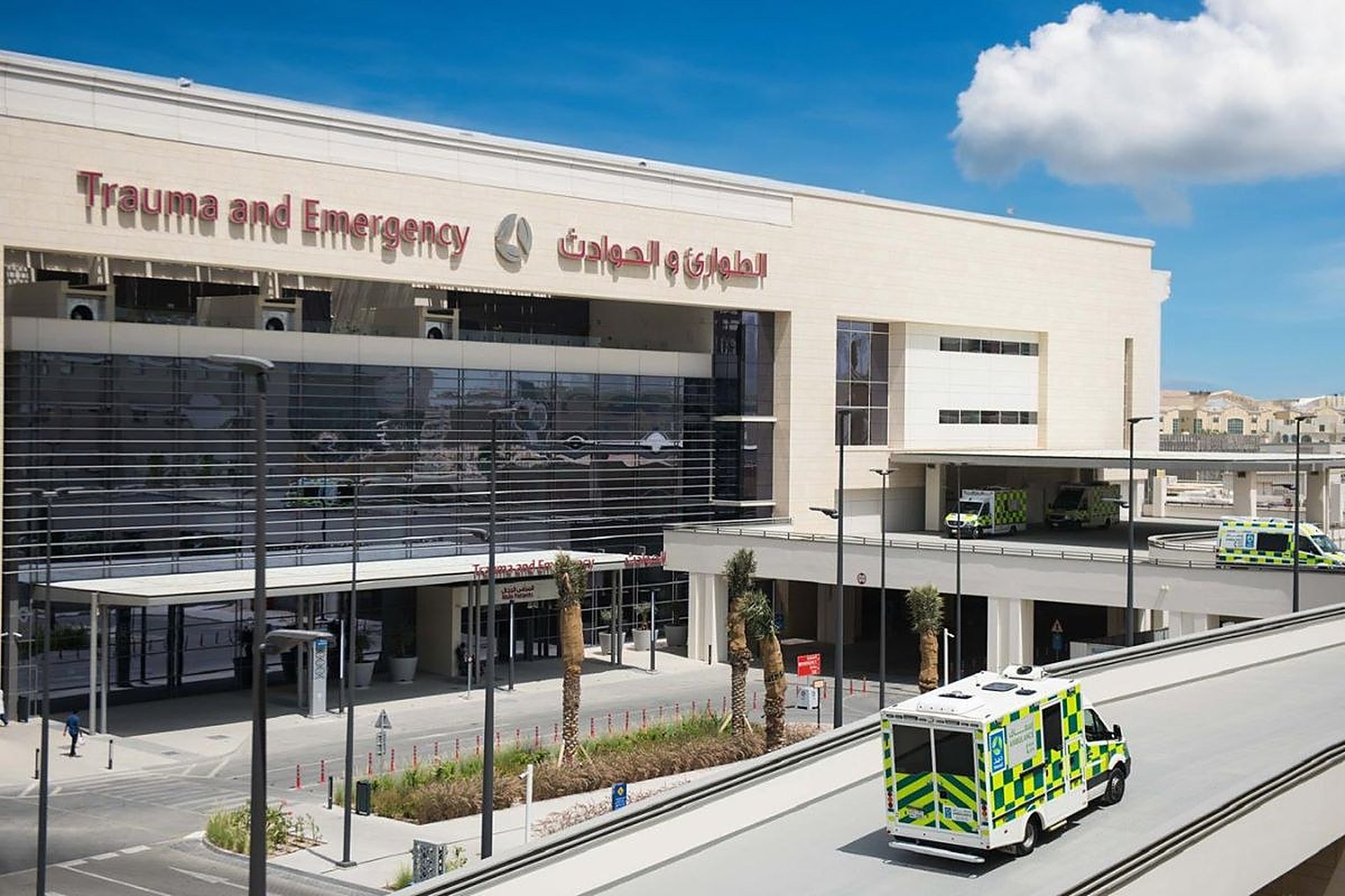 L'entrée du service Trauma and Emergency de Hamad Medical Corporation à Doha, façade de verre, une ambulance devant
