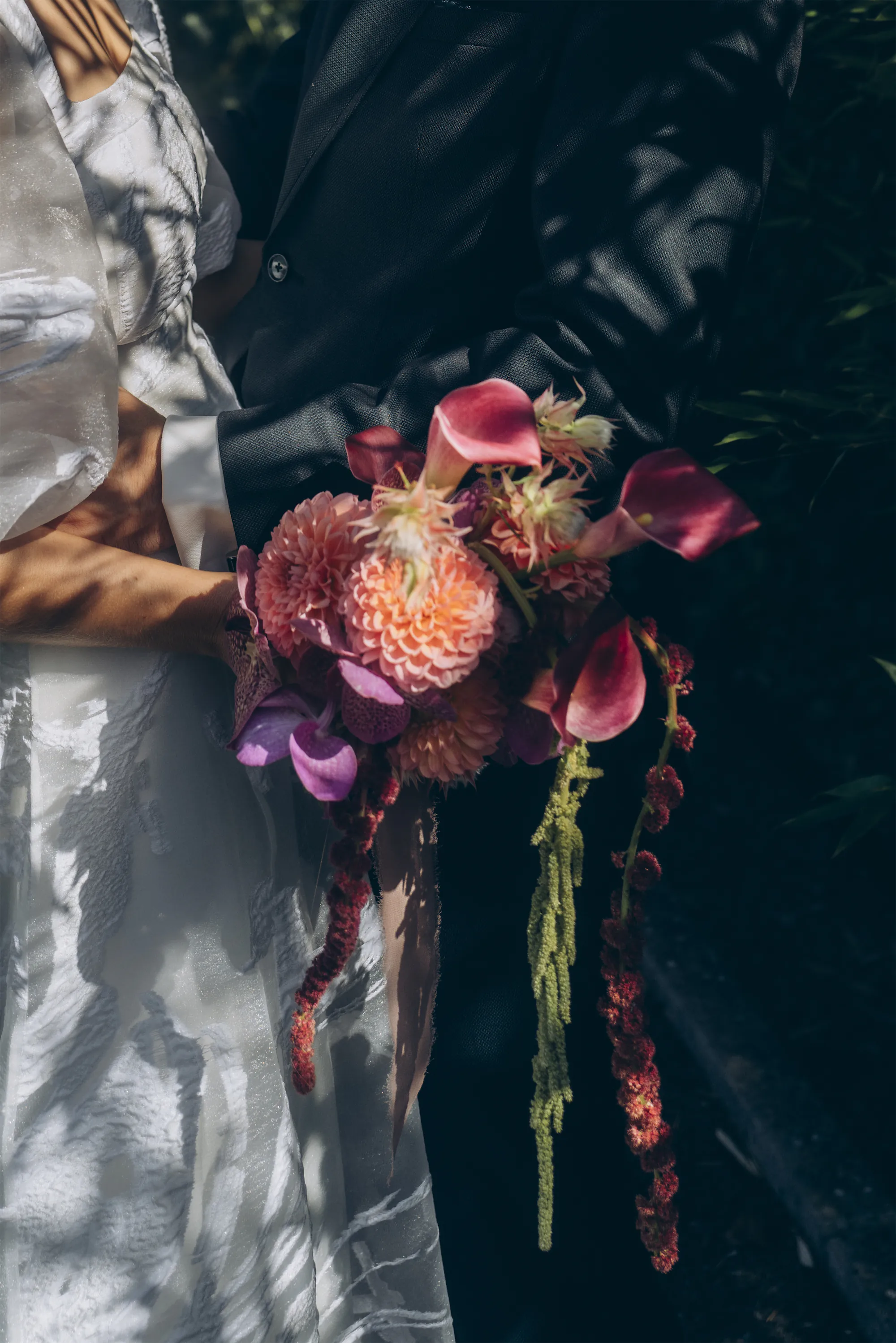 Artistic close-up of bride’s hands holding bouquet at emotional wedding ceremony