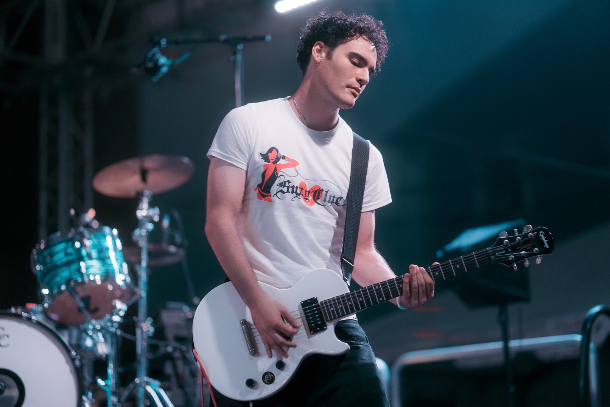 Young 20's guy playing guitar on stage