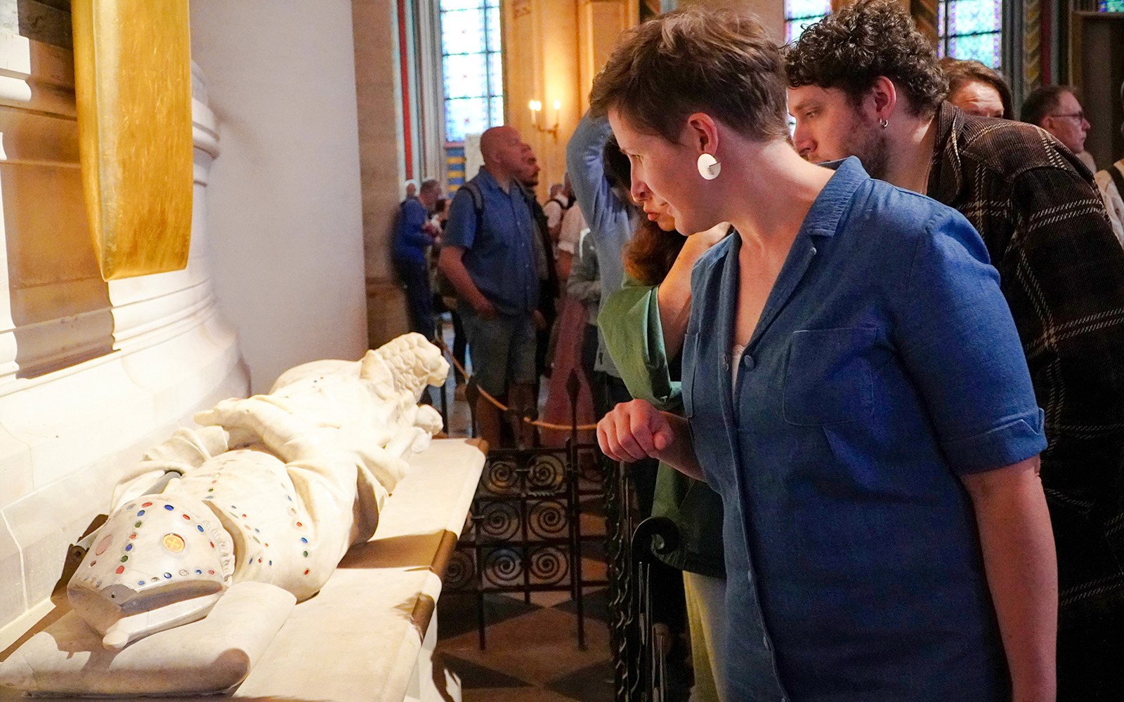 Guide som undersøker en historisk gjenstand inne i Notre Dame-katedralen.