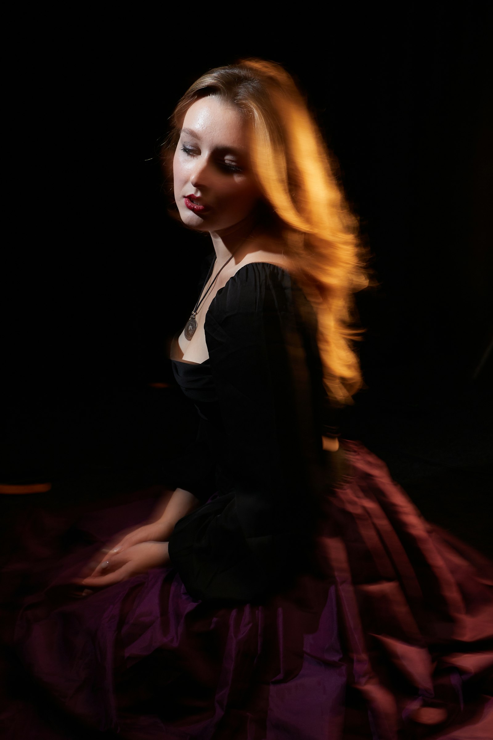 Model with flowing hair in a dark dress