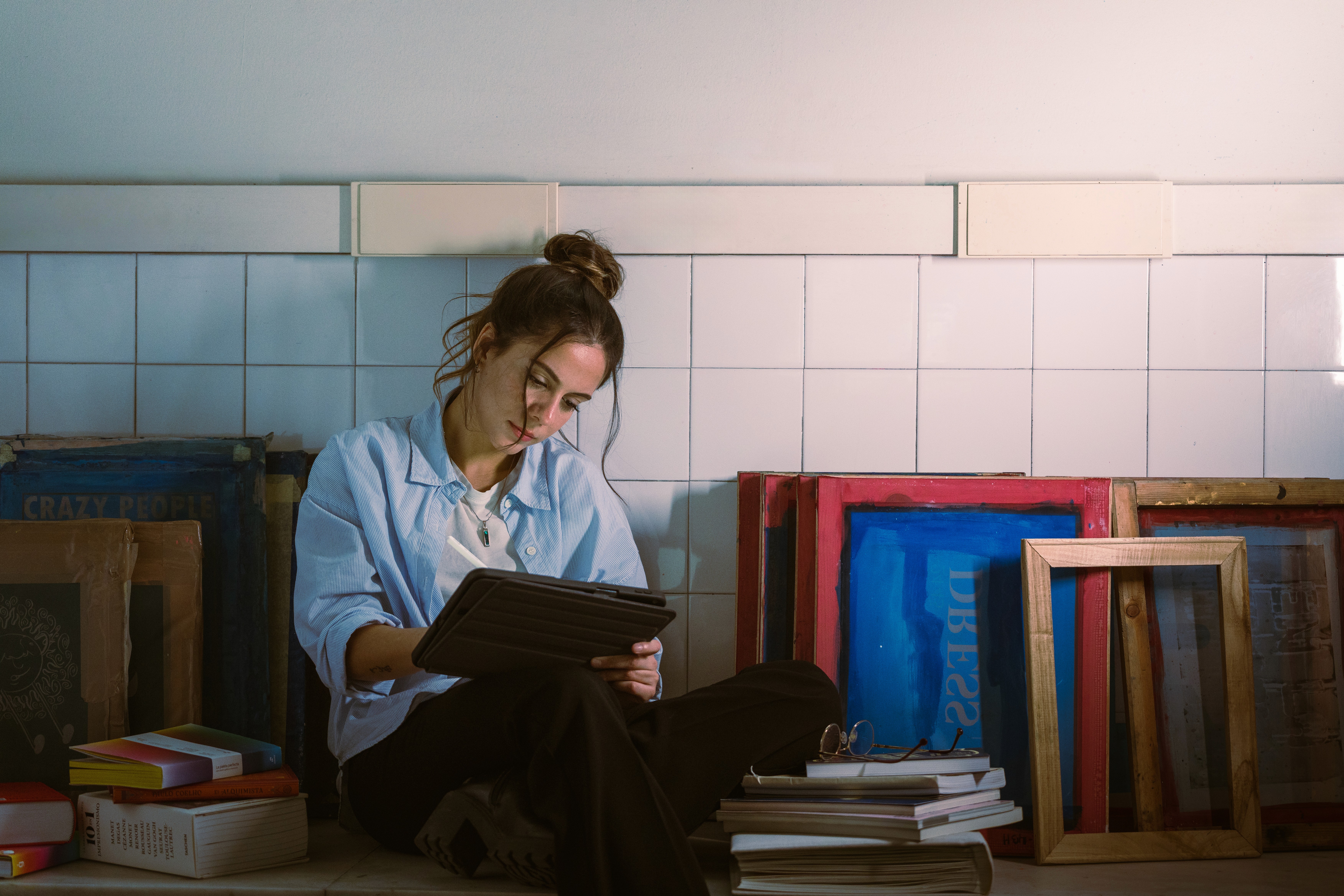 Close-up portrait of a person wearing a gray insulated hooded jacket with the hood up, showing their face framed by the hood against a light background.