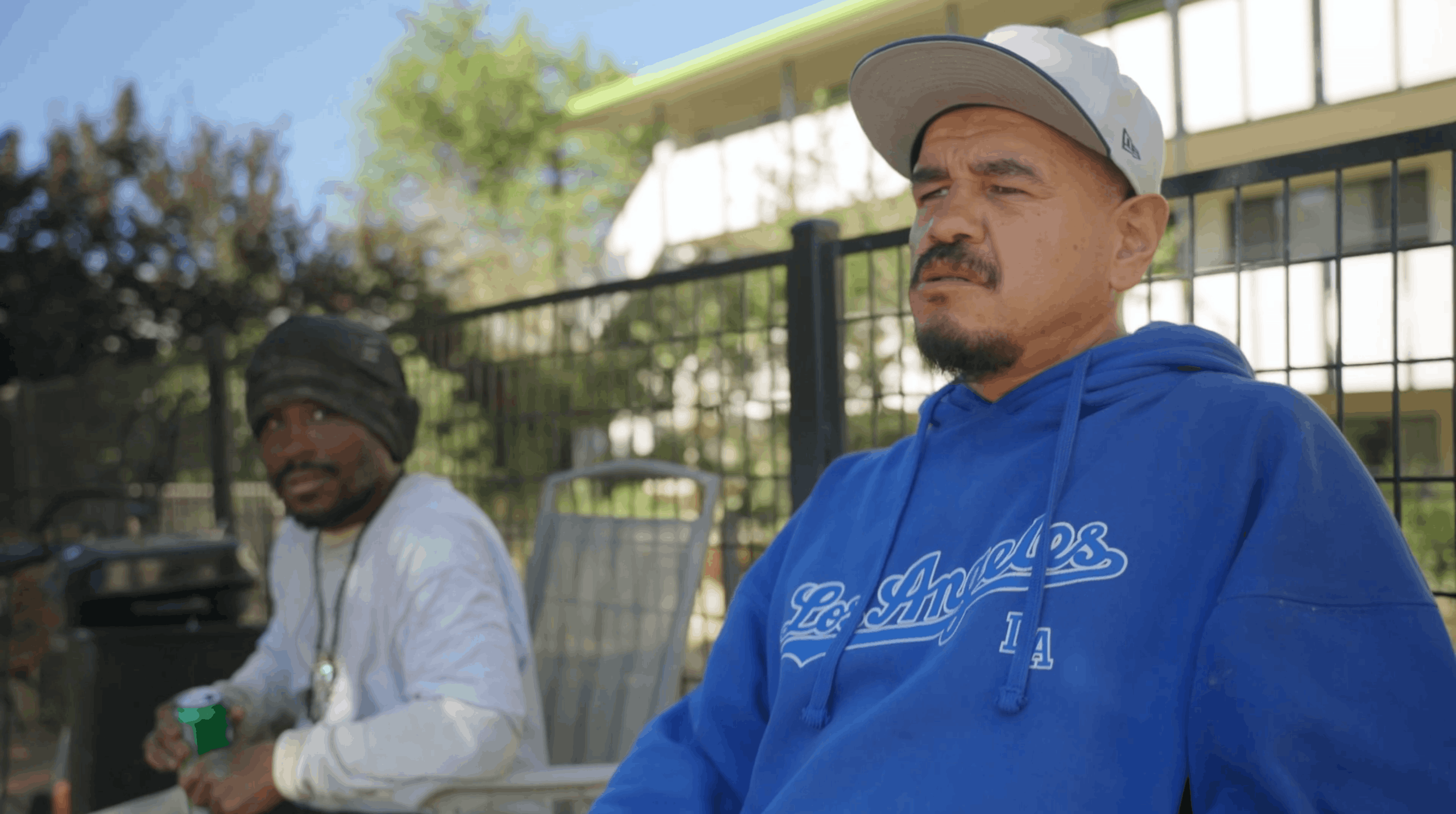 two residents sitting and talking together in an outdoor courtyard at ananeo