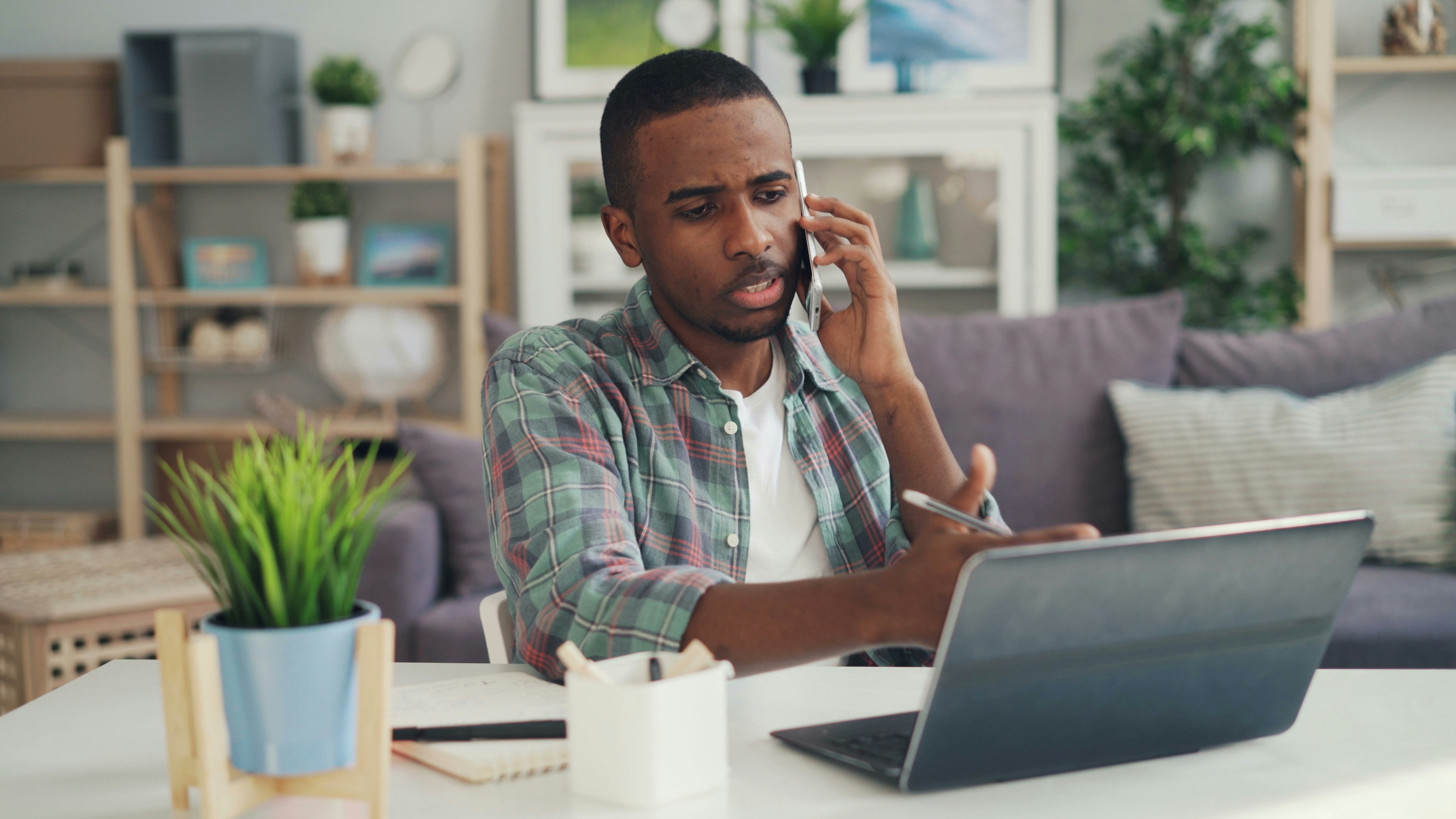 a man sitting at a table talking on a cell phone