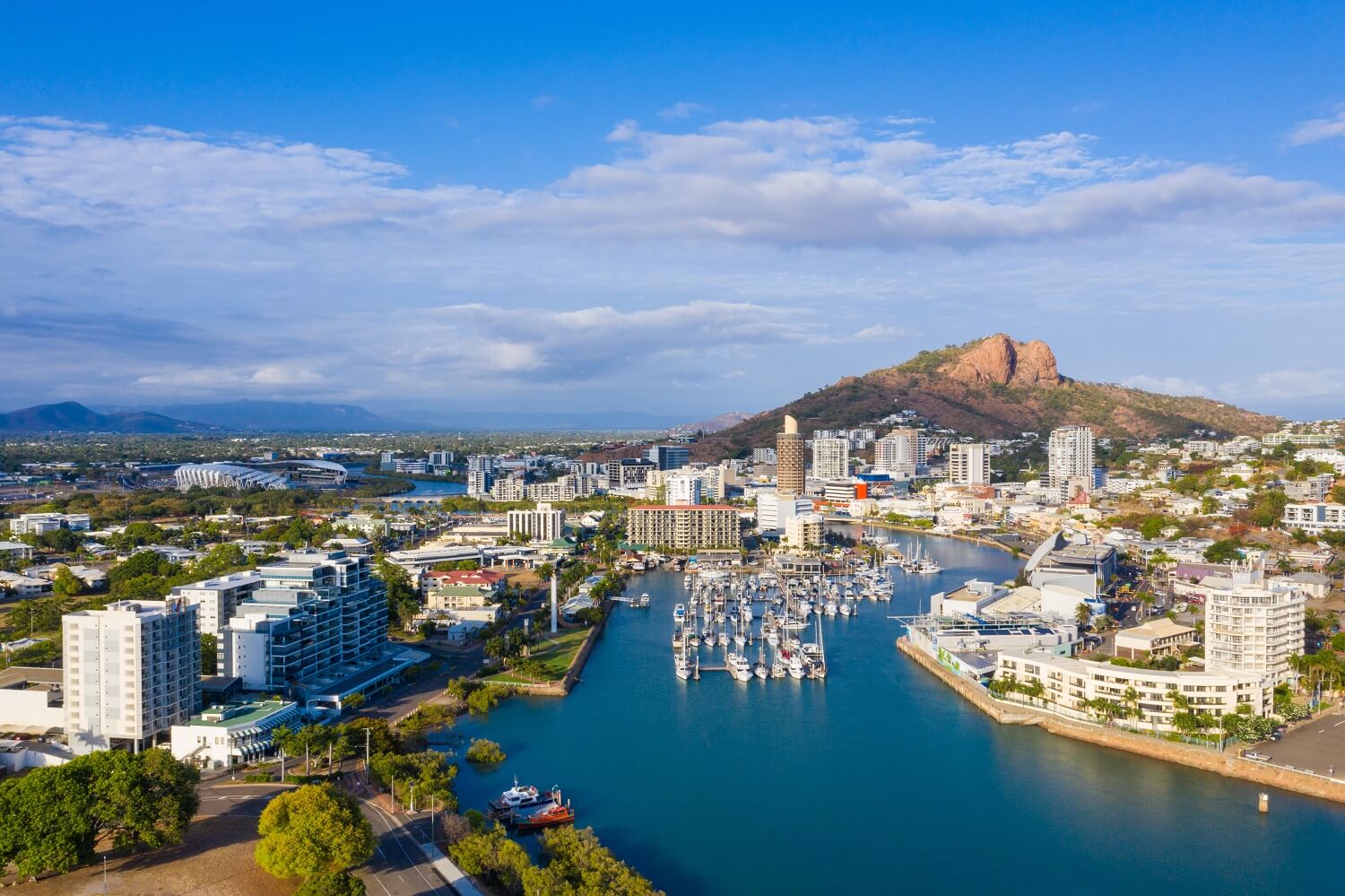 Marina and city skyline with a prominent rocky hill behind