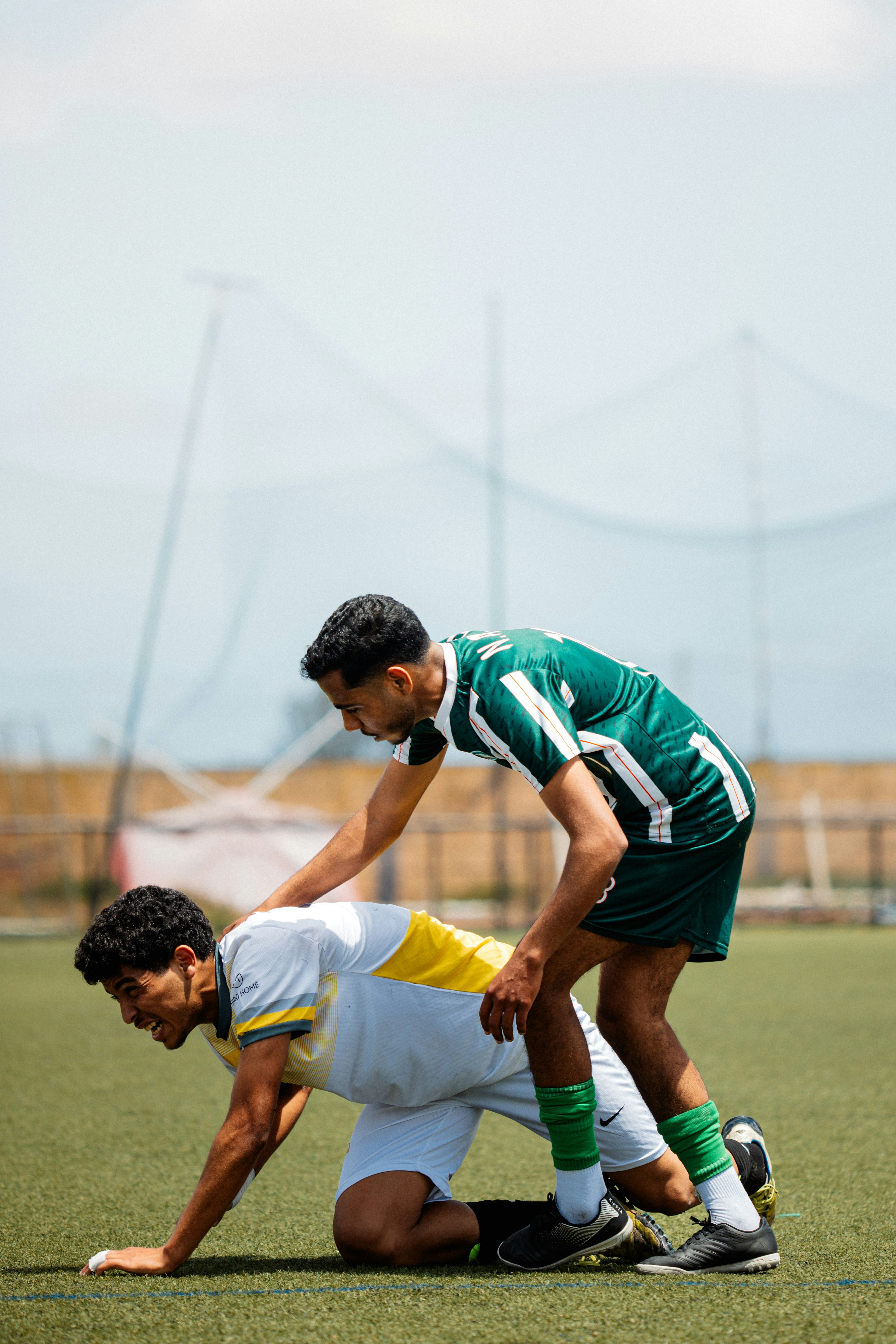 A soccer player is helping a teammate.