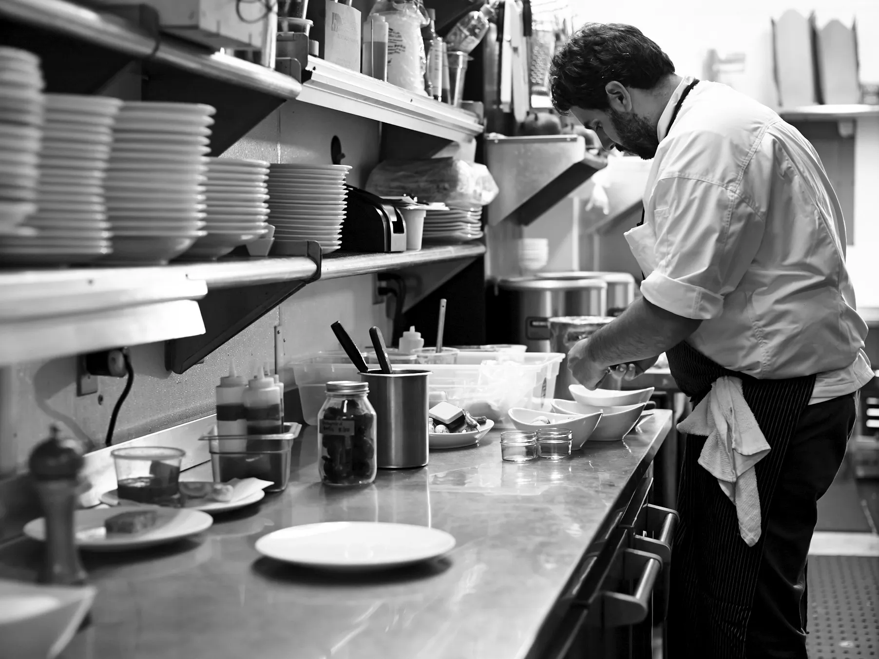 Chef preparing fresh dishes in a professional kitchen for a private dining experience.