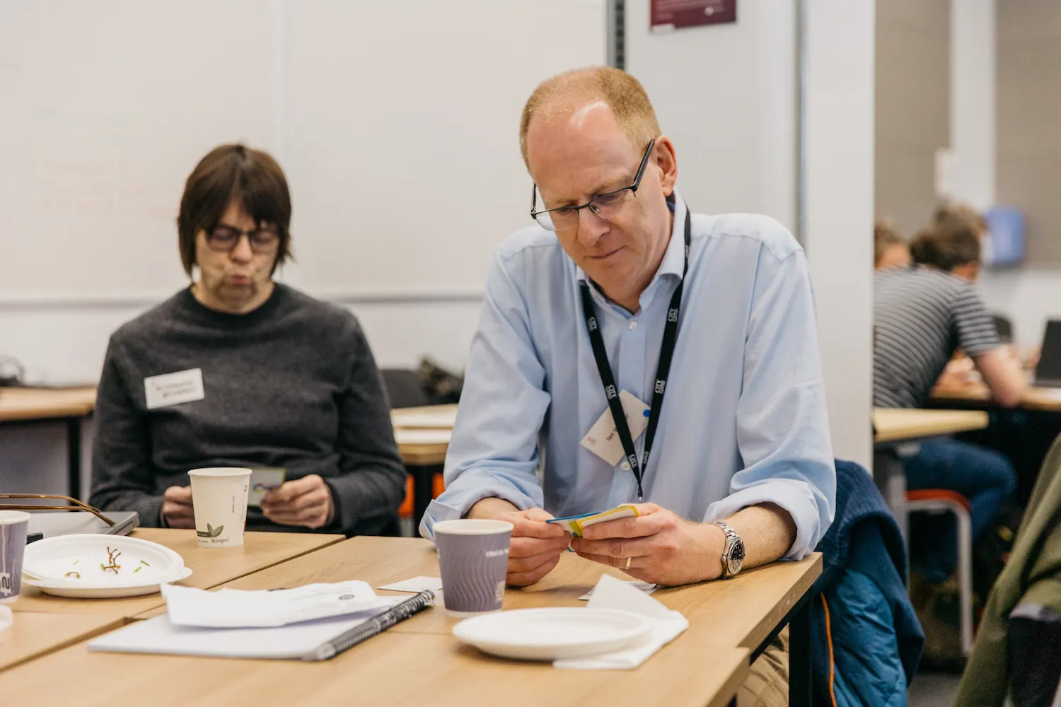 People working at an office table with notebooks and papers.