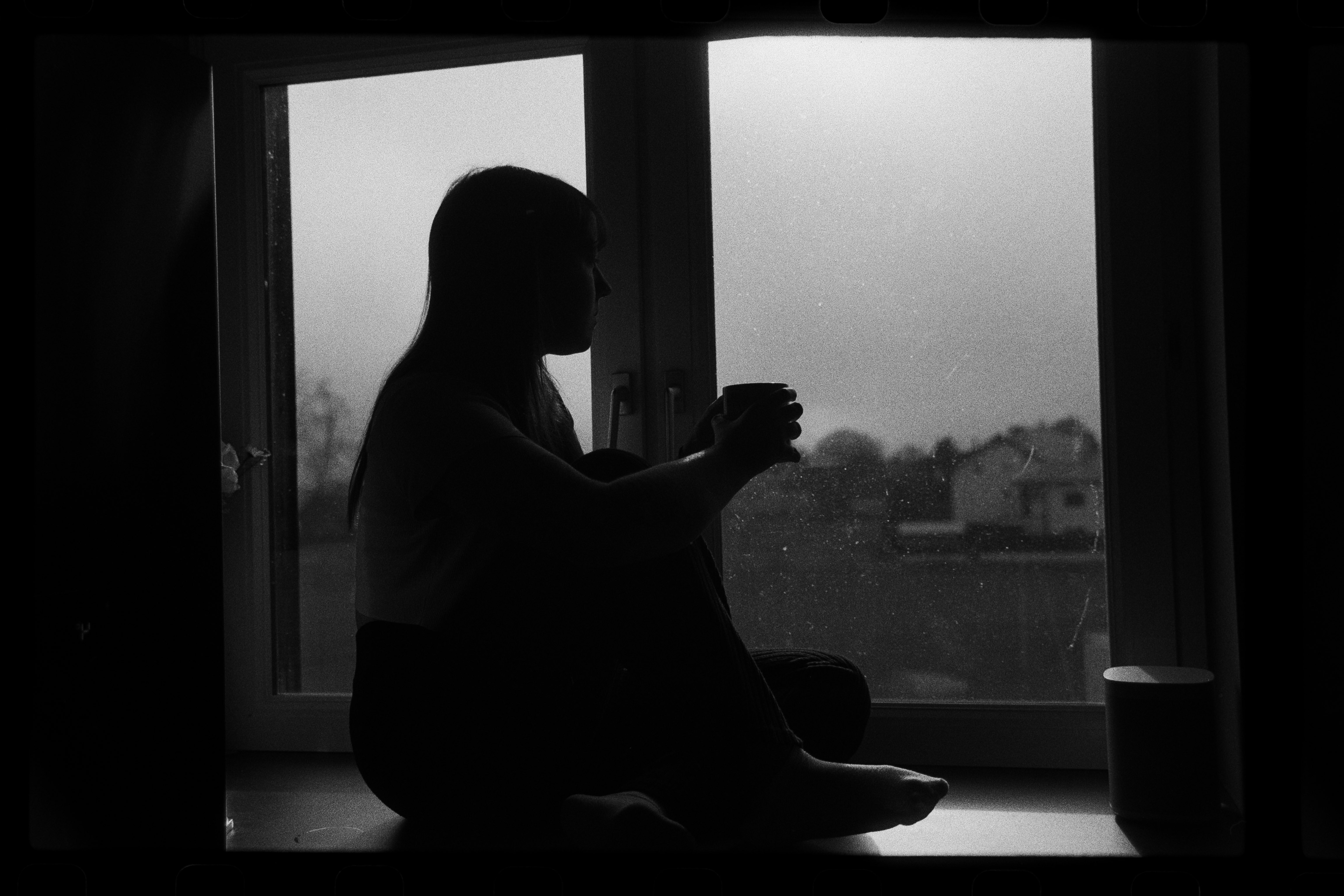 A close-up of a pink cocktail in a martini glass, set against a nighttime background with soft, blurred colors.