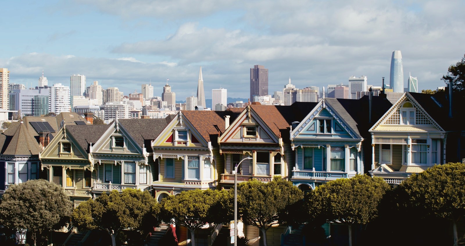 Row of residential homes with the San Francisco skyline behind them
