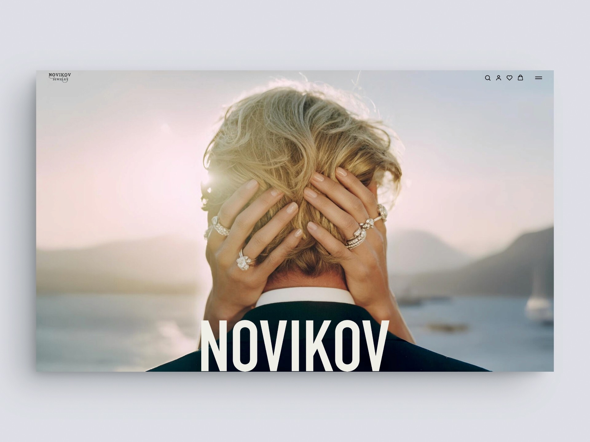 Close-up of a couple embracing with a mountain and sea view behind them, Novikov text below.