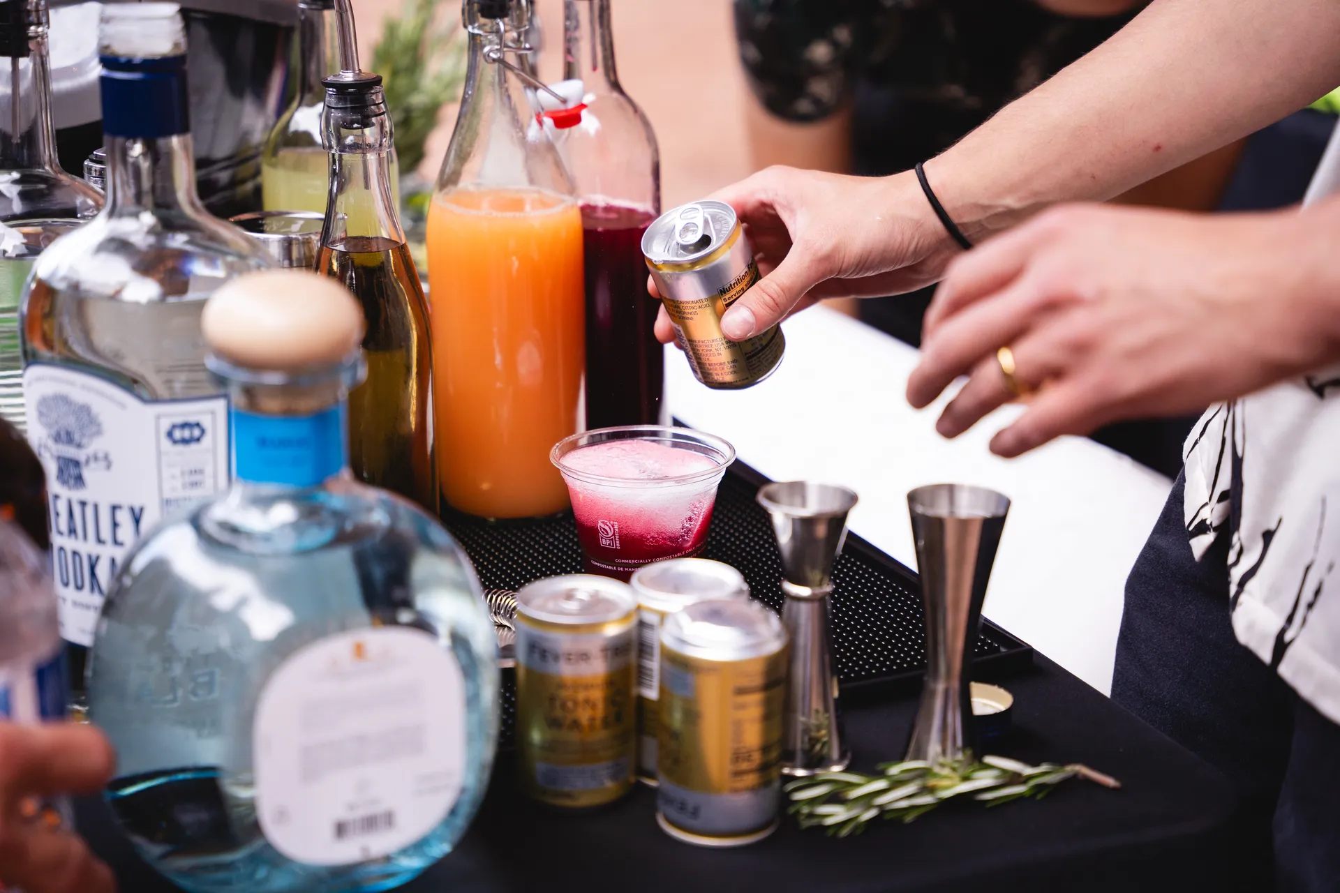 Topping off a cocktail with tonic on a pop up table