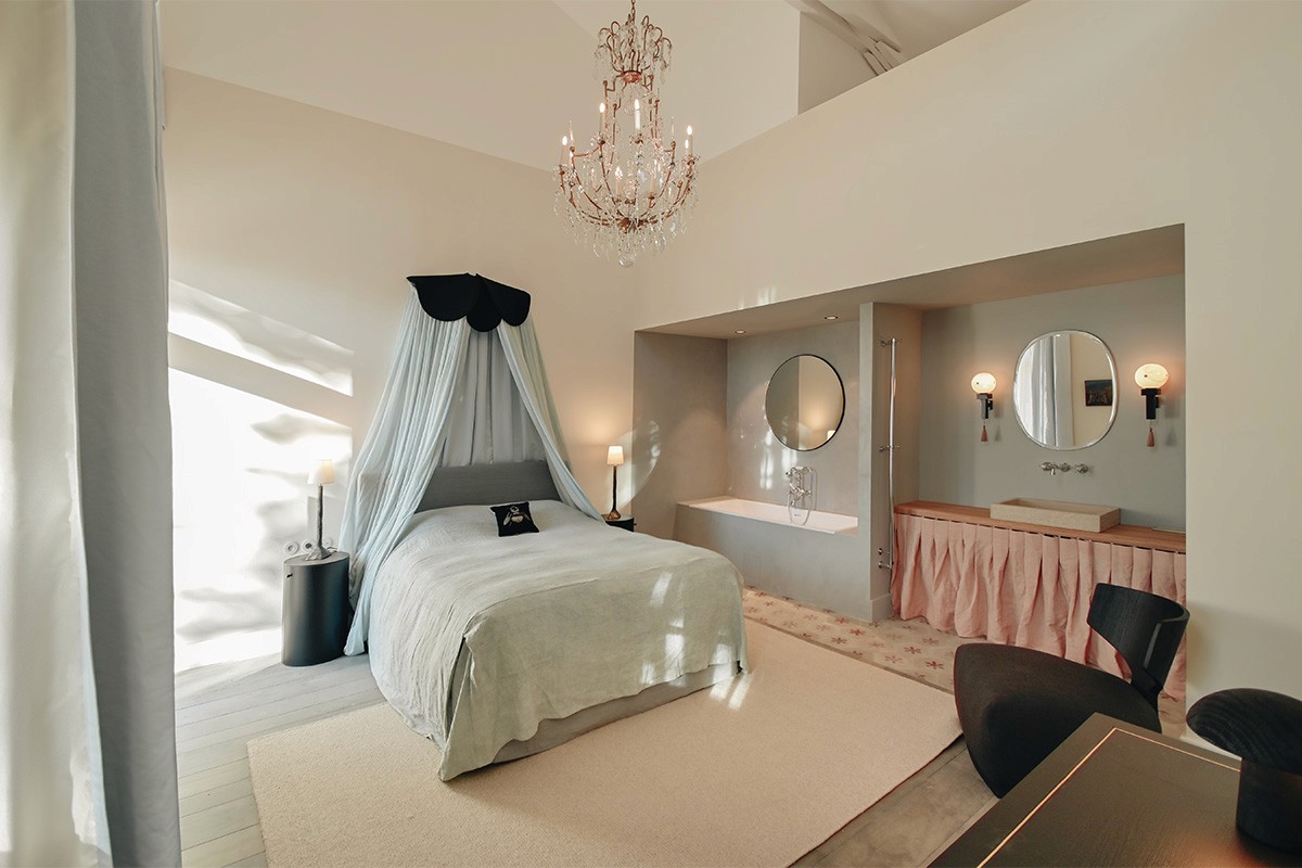 suite hôtelière, suite de prestige, suite haut de gamme, chambre d’hôtel de charme, hébergement de luxe, hébergement de caractère, rénovation hôtelière, architecture hôtelière, design hôtelier, hôtel de charme, domaine de réception, domaine événementiel, suite événementielle, hébergement pour mariage, hébergement pour séminaire, suite romantique, chambre premium, expérience hôtelière haut de gamme.  rénovation patrimoine, réhabilitation patrimoine bâti, rénovation dépendances de château, château de la Banquière, architecture du patrimoine, rénovation de prestige, conservation du patrimoine, valorisation de l'existant, architecture contemporaine et patrimoine, restauration bâtiment ancien, domaine historique, réhabilitation domaine de caractère.  charpente apparente, poutres anciennes, poutres en bois massif, structure historique conservée, matériaux anciens, pierre et bois, authenticité architecturale, volumes existants, rénovation respectueuse du patrimoine, détails architecturaux, matériaux nobles, caractère historique, charme de l'ancien, patrimoine rénové.  suite sous charpente, chambre avec poutres apparentes, volume cathédrale, plafond mansardé, architecture intérieure patrimoniale, chambre de caractère, suite en double hauteur, architecture intérieure haut de gamme, aménagement sur mesure, design intérieur contemporain, décoration raffinée, élégance intemporelle, ambiance chaleureuse, atmosphère intimiste, confort hôtelier.  mobilier sur mesure, décoration haut de gamme, design contemporain, architecture intérieure, aménagement intérieur, chambre minimaliste, matériaux naturels, finitions soignées, éclairage décoratif, miroir design, mobilier intégré, suite contemporaine, luxe discret, raffinement architectural, expérience client premium.  architecte patrimoine Montpellier, architecte patrimoine Nîmes, architecte patrimoine Perpignan, rénovation château Montpellier, rénovation domaine historique, rénovation hôtel de charme, rénovation suites hôtelières, réhabilitation patrimoine Occitanie, architecte Occitanie, agence d'architecture patrimoine, maîtrise d'œuvre patrimoine, rénovation de prestige Occitanie.