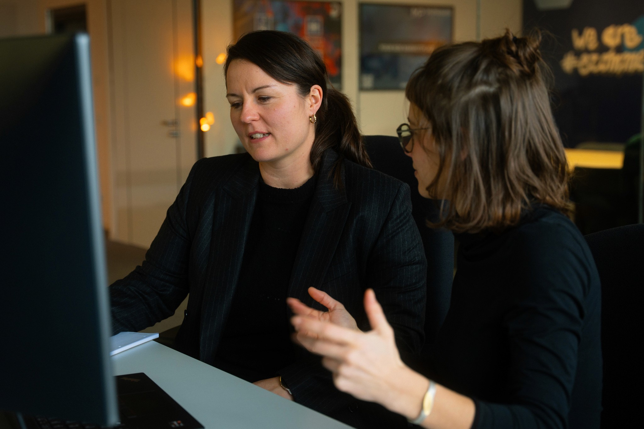 woman in blue tank top standing beside white wall