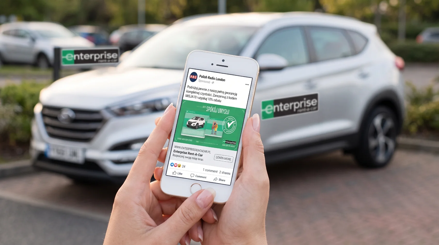 Hands holding iPhone showing Polish Enterprise Rent-A-Car ad via Polish Radio London with Enterprise SUV in background