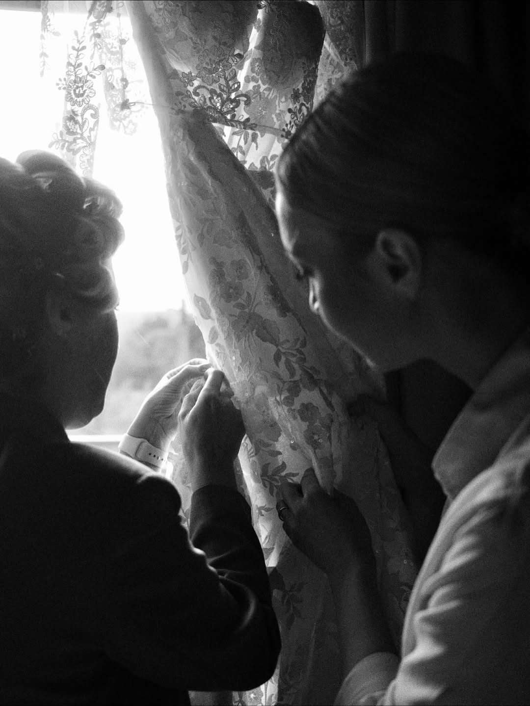 Two women fixing up a wedding dress