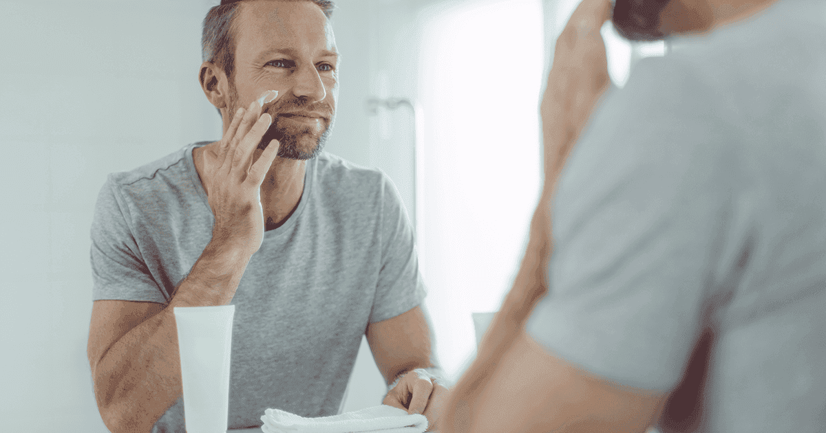 Person applying skincare while looking in a mirror
