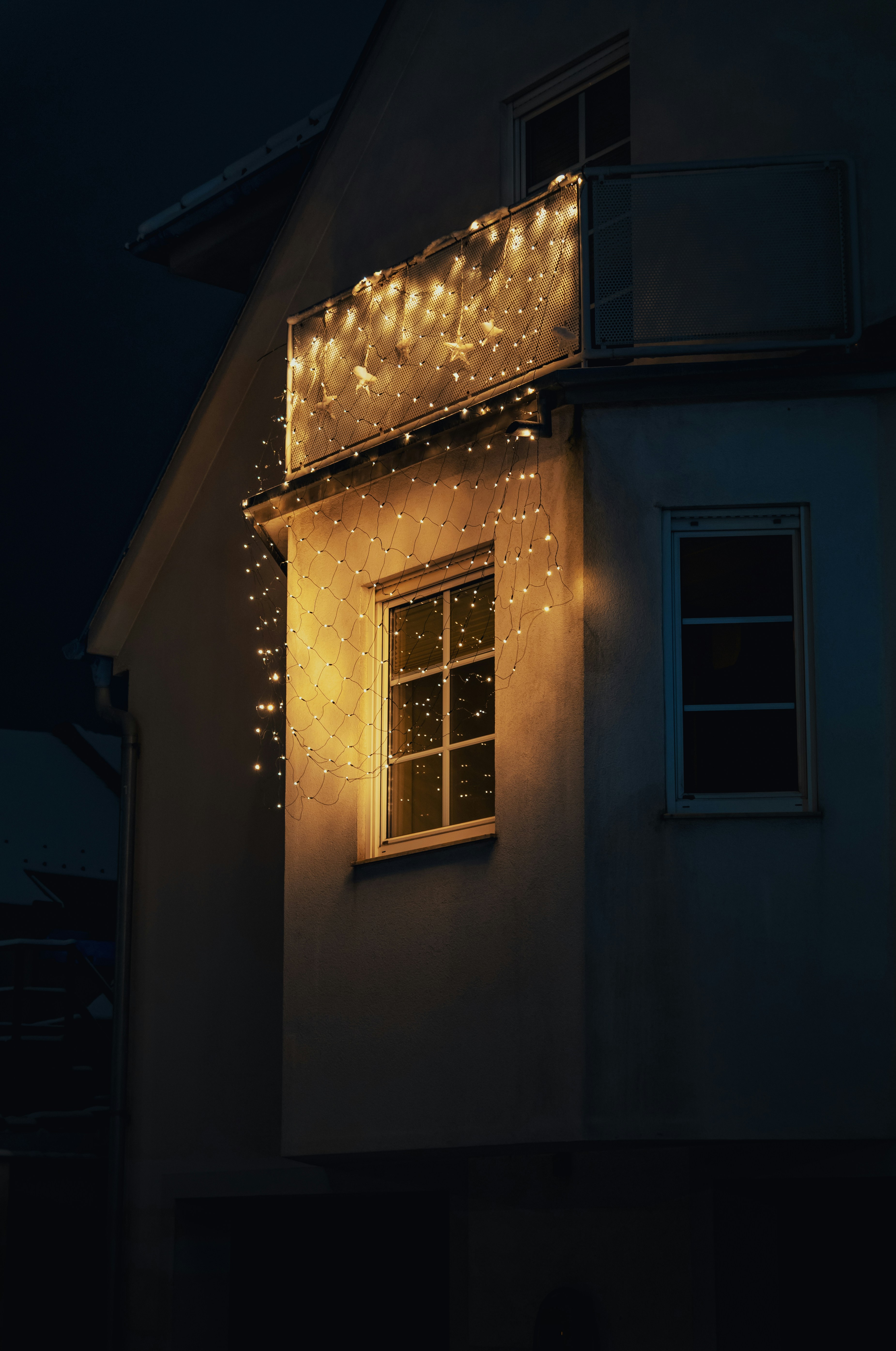 A house illuminated by warm string lights at night.