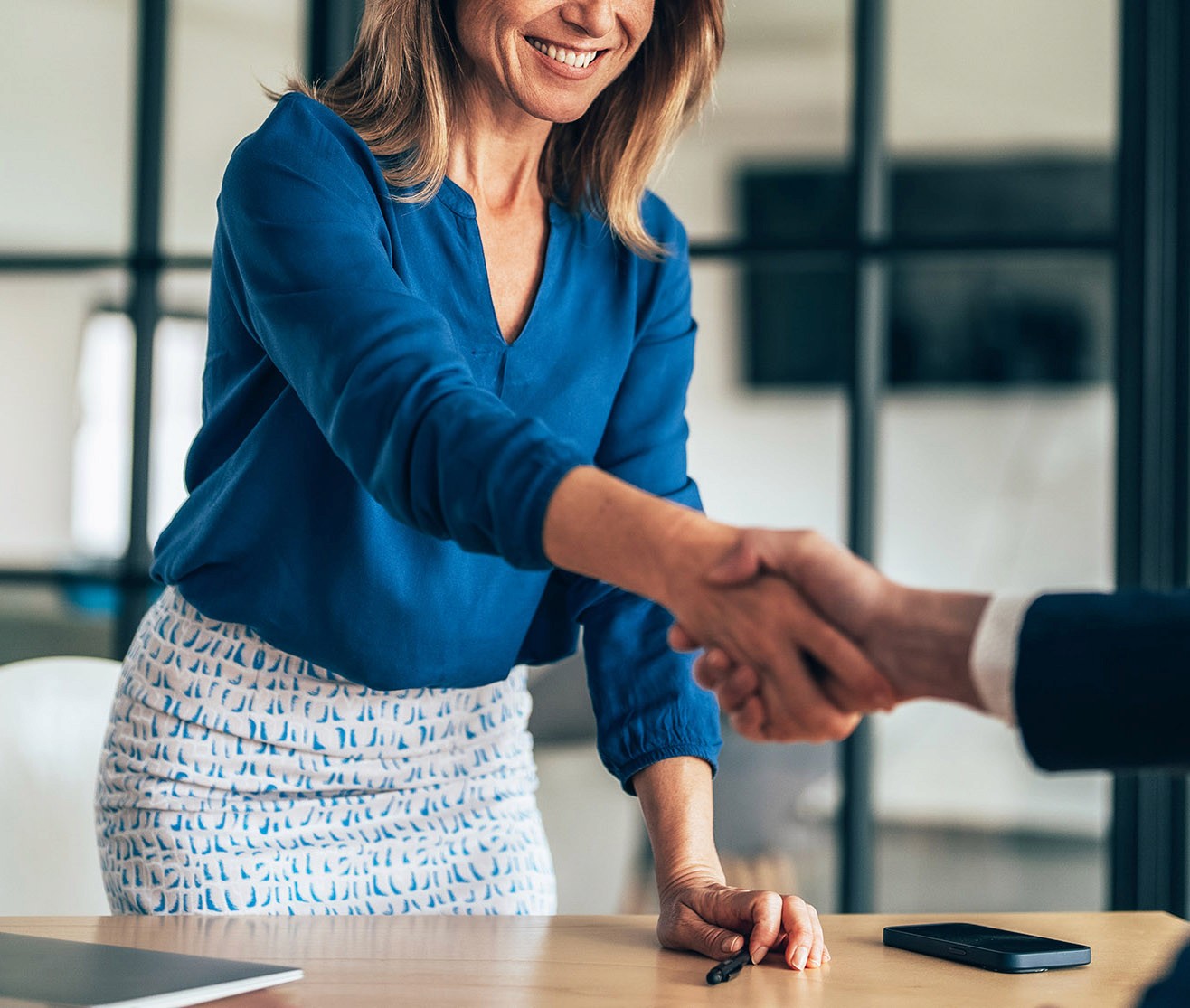 Woman shaking hand in business meeting.