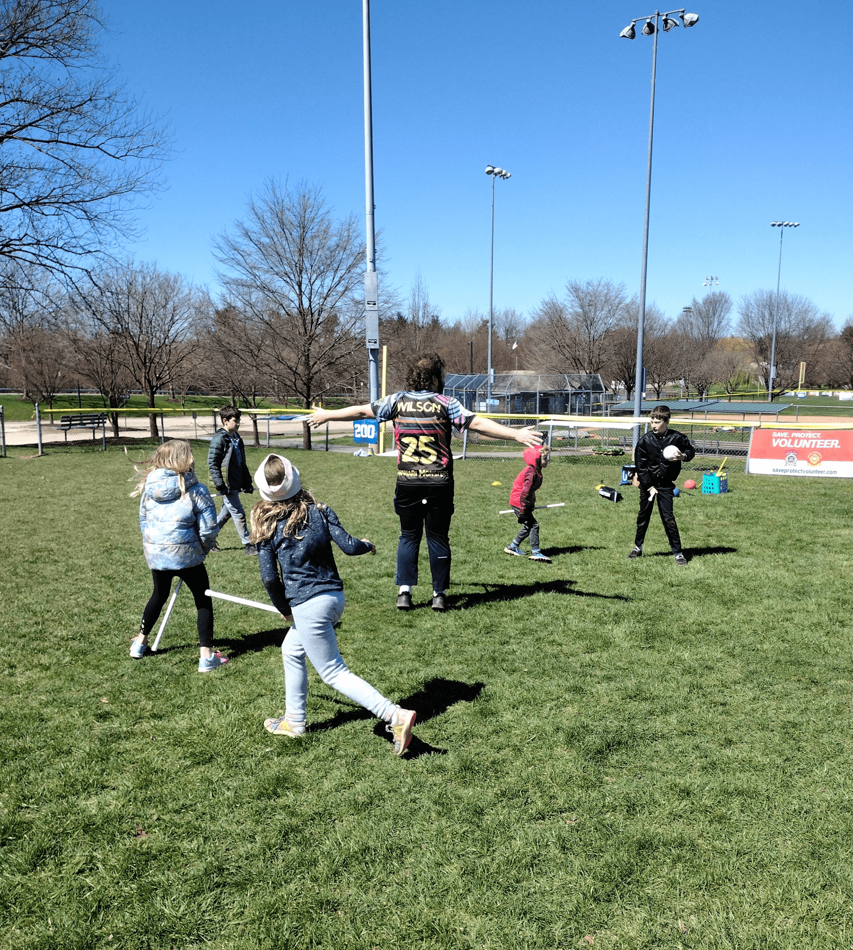 An organizer plays alongside kids during a Kidditch event 