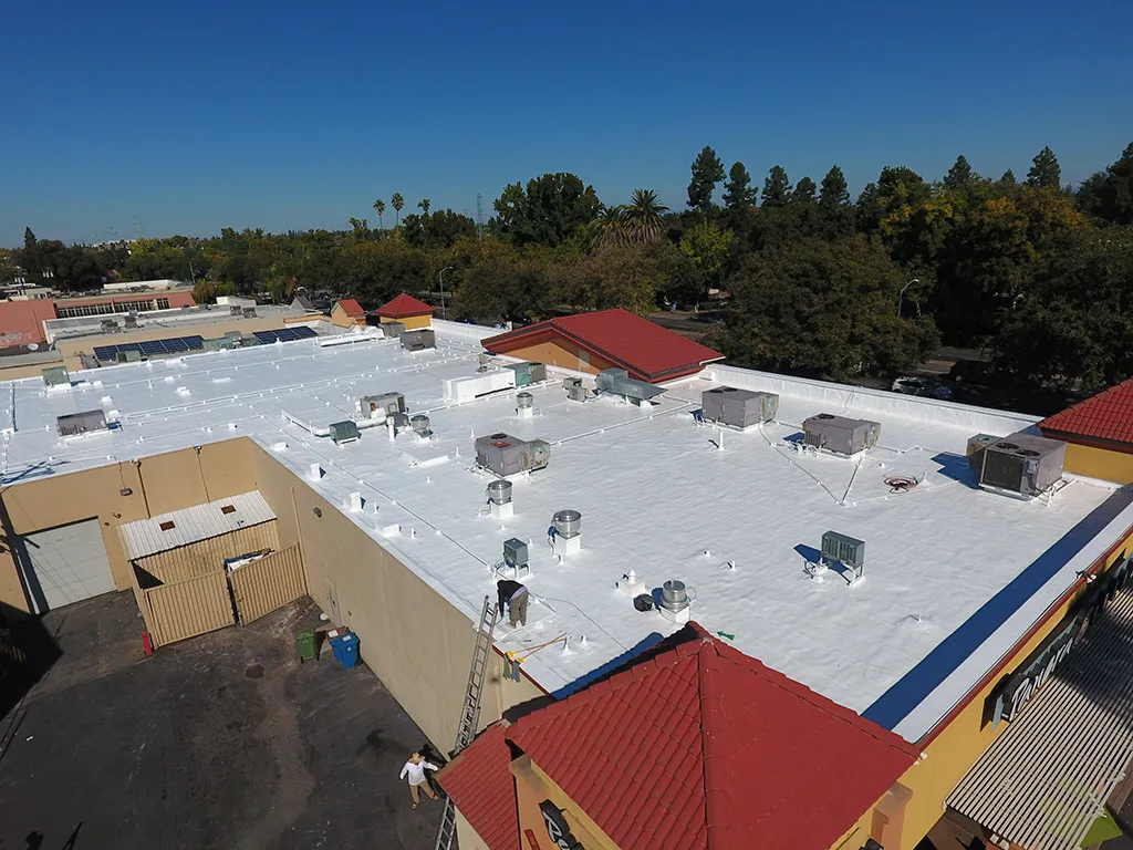 Commercial corrugated metal roof cleaned and primed for spray foam roofing system