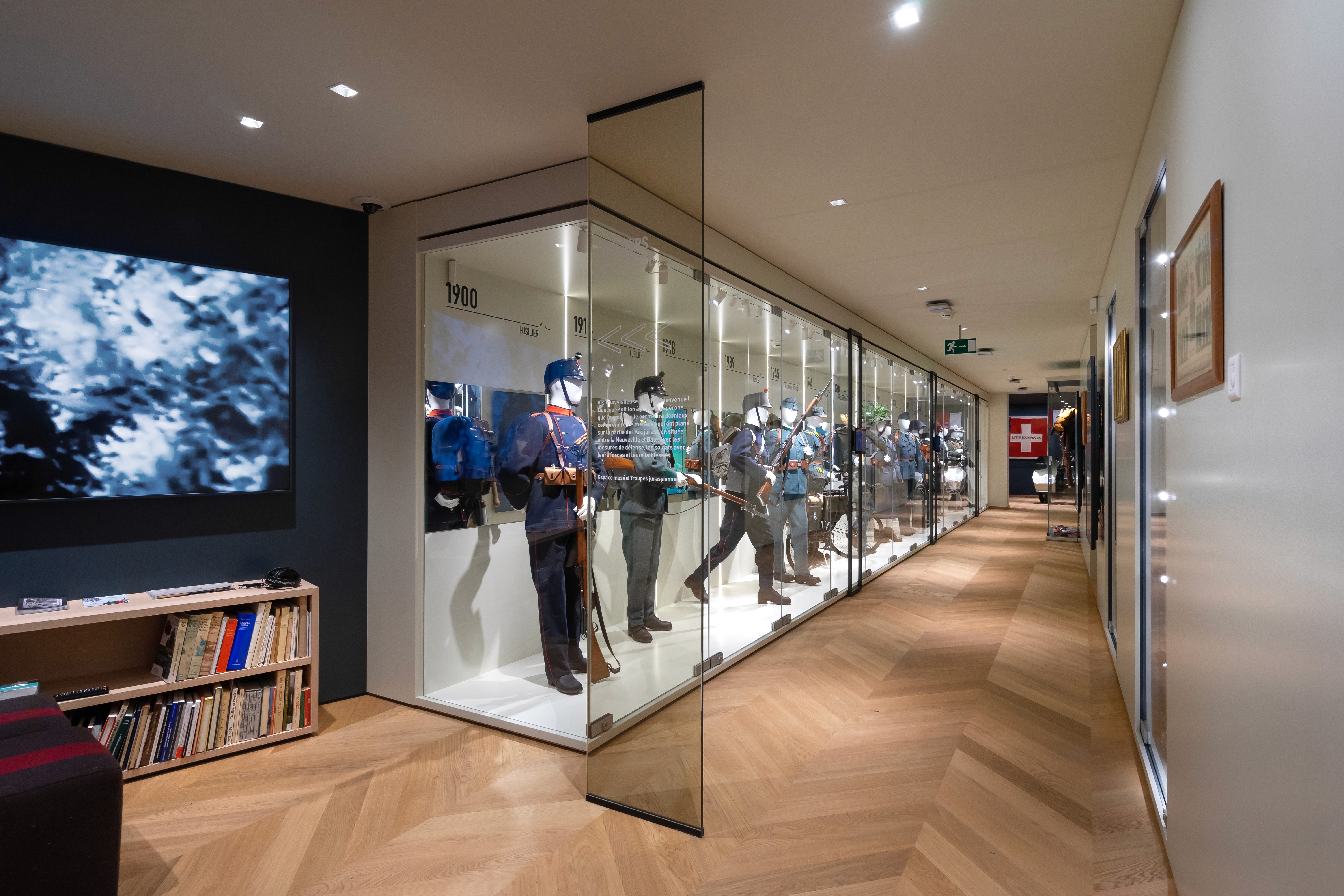 Wooden floor and suits inside display showcases  in an exhibition design concept of a museum retail for Switzerland 