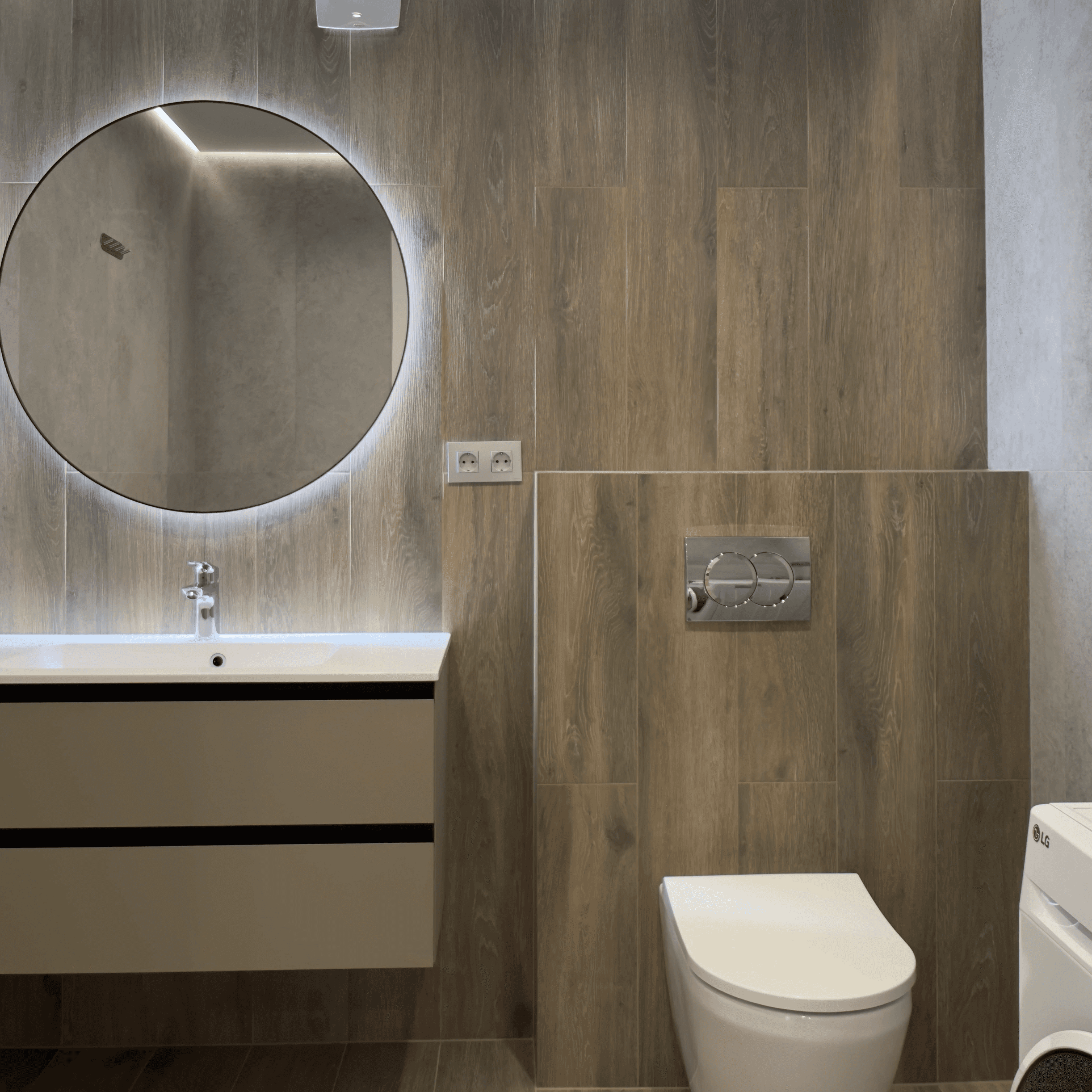 Санвузол з унітазом, пральною машиною, круглим дзеркалом і дерев’яним оздобленням