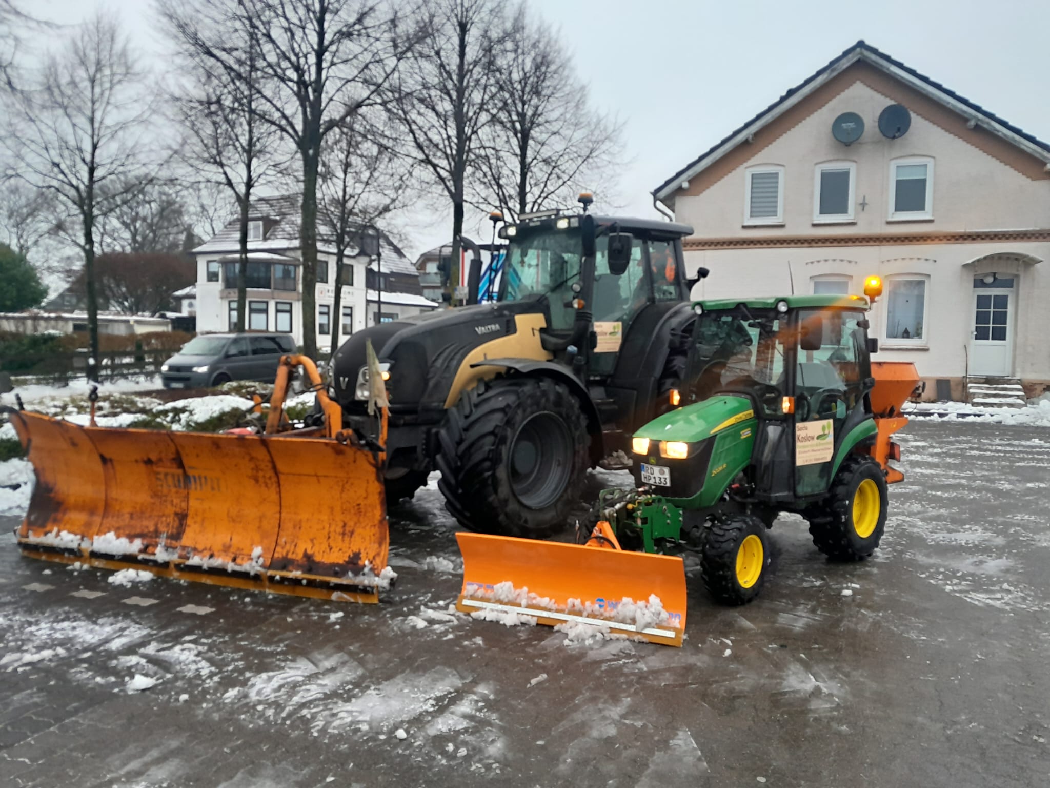 Zwei Traktoren mit Schneeschildern im Winterdienst