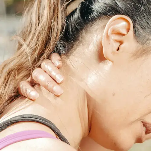 Person holding the back of the neck due to cervical pain