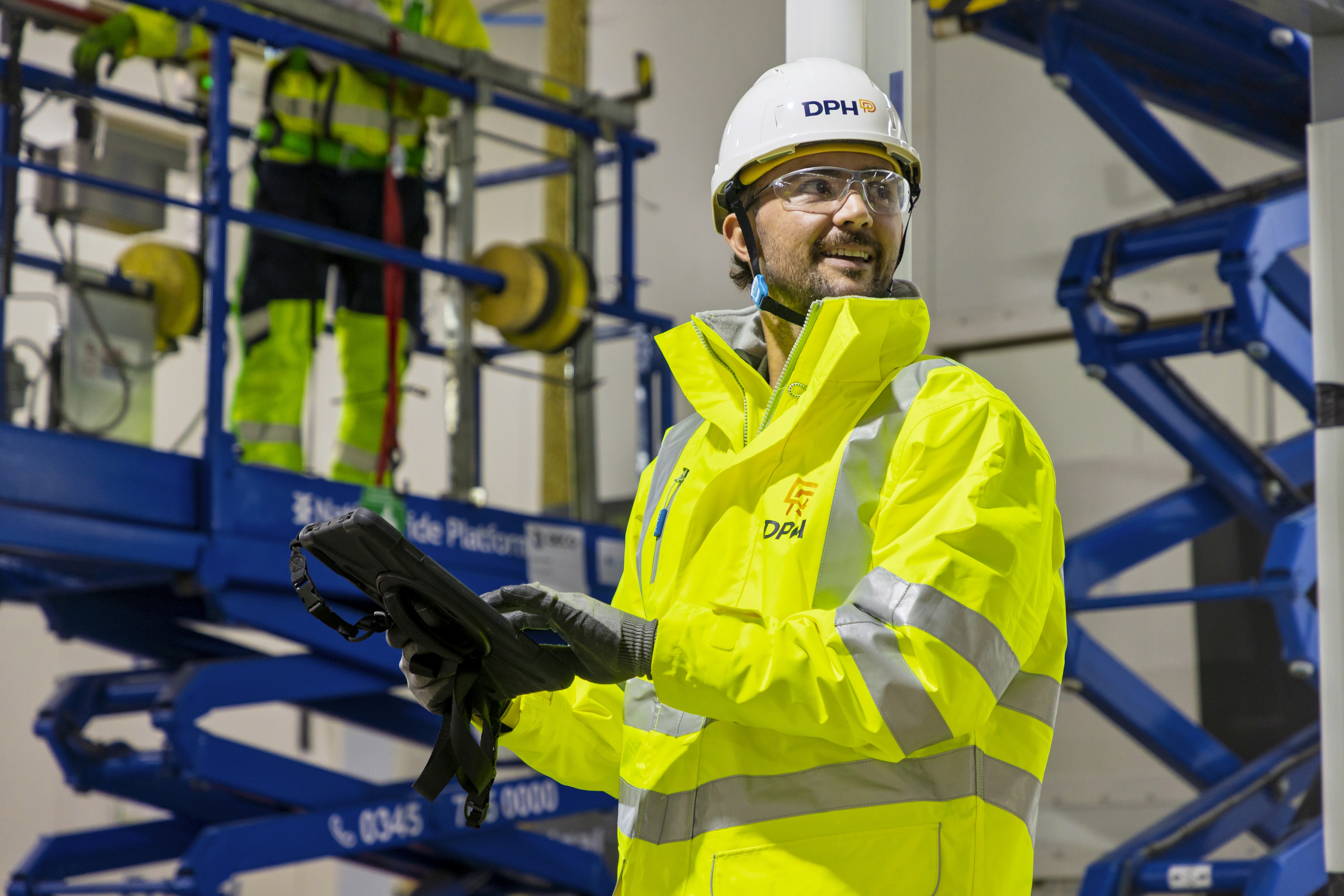 Entrance of a modern glass building with illuminated facade and reflections