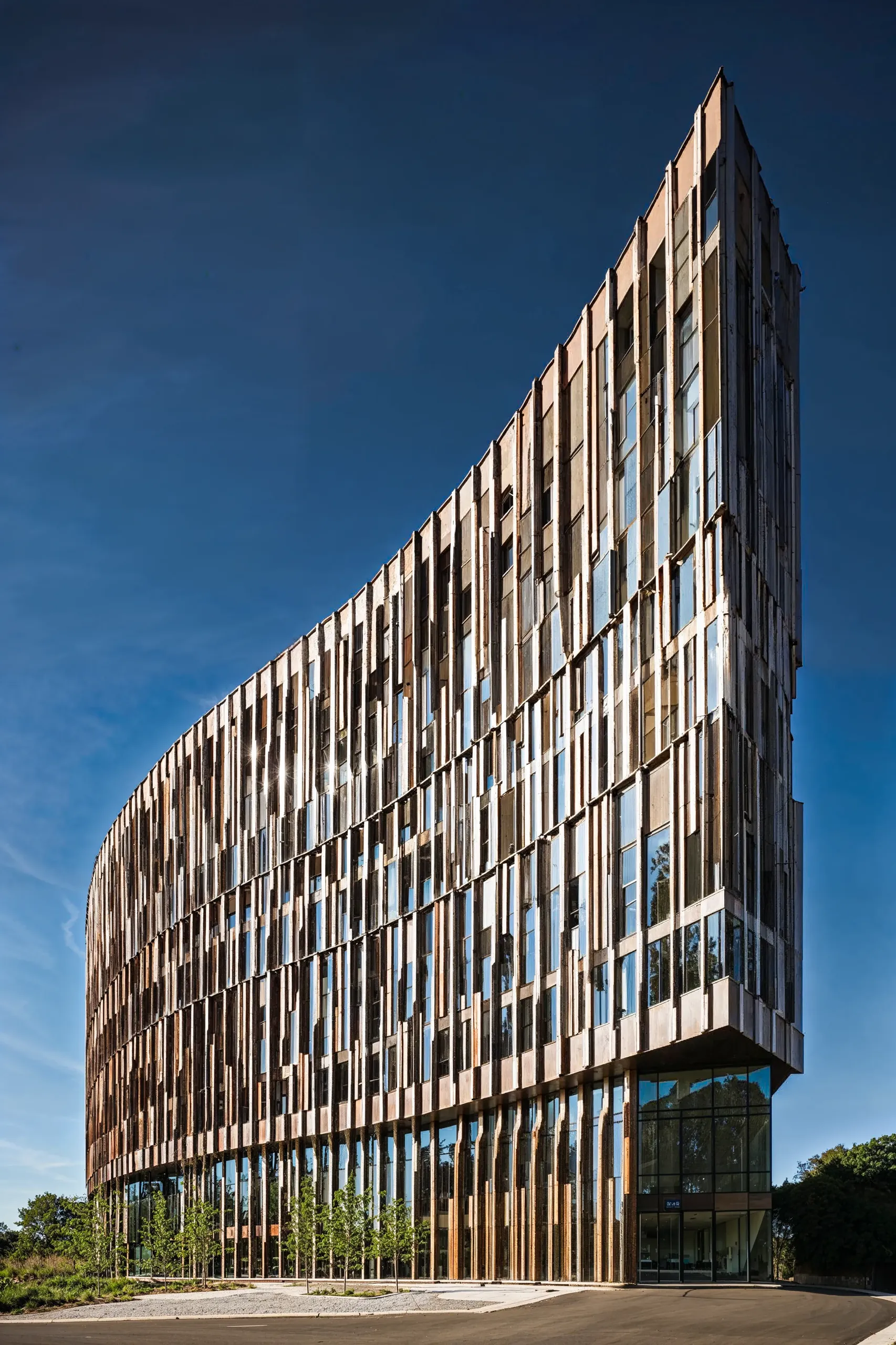 Photorealistic render of a contemporary high-rise building with dynamic facade design against a clear sky.
