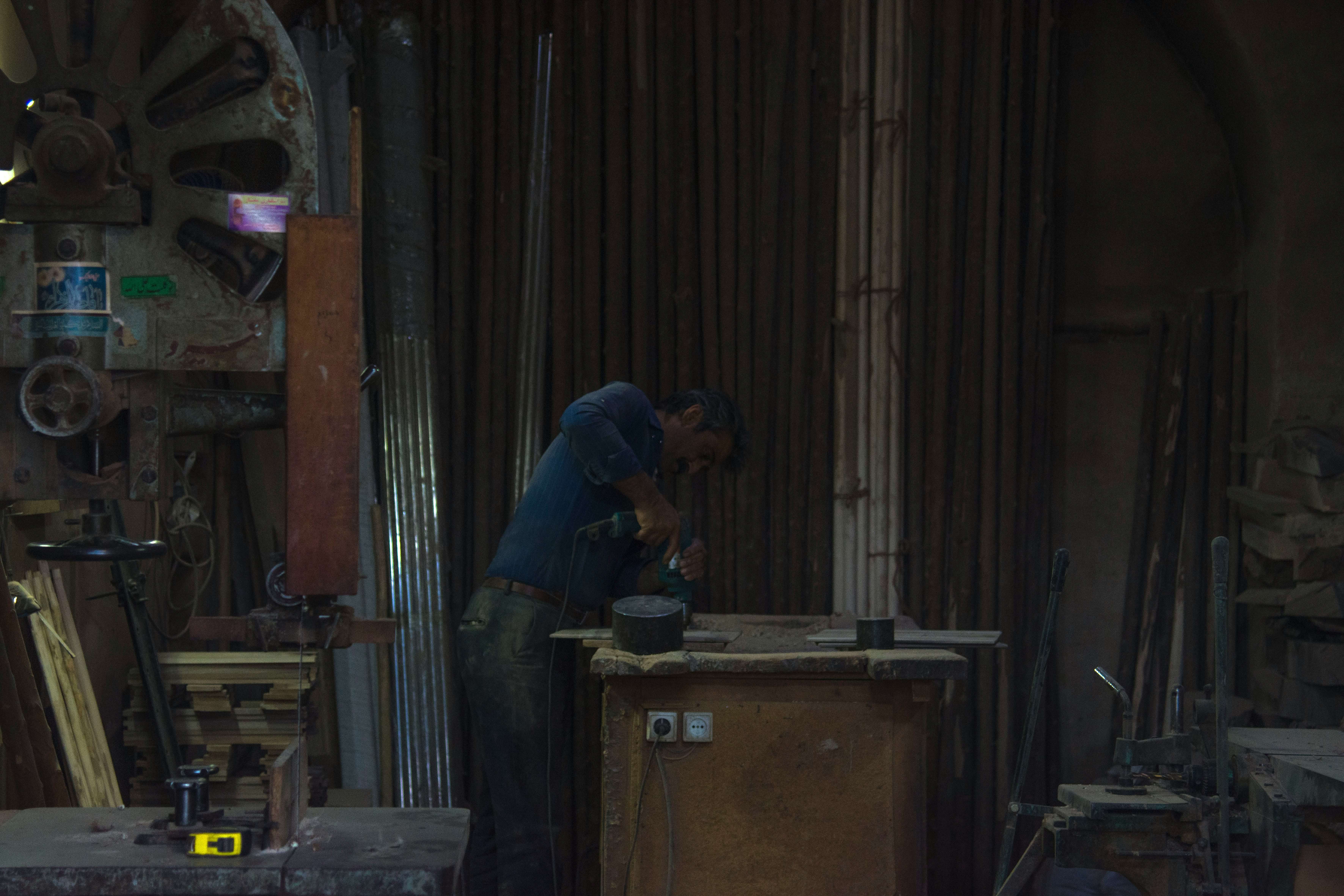 Carpenter in blue shirt working.