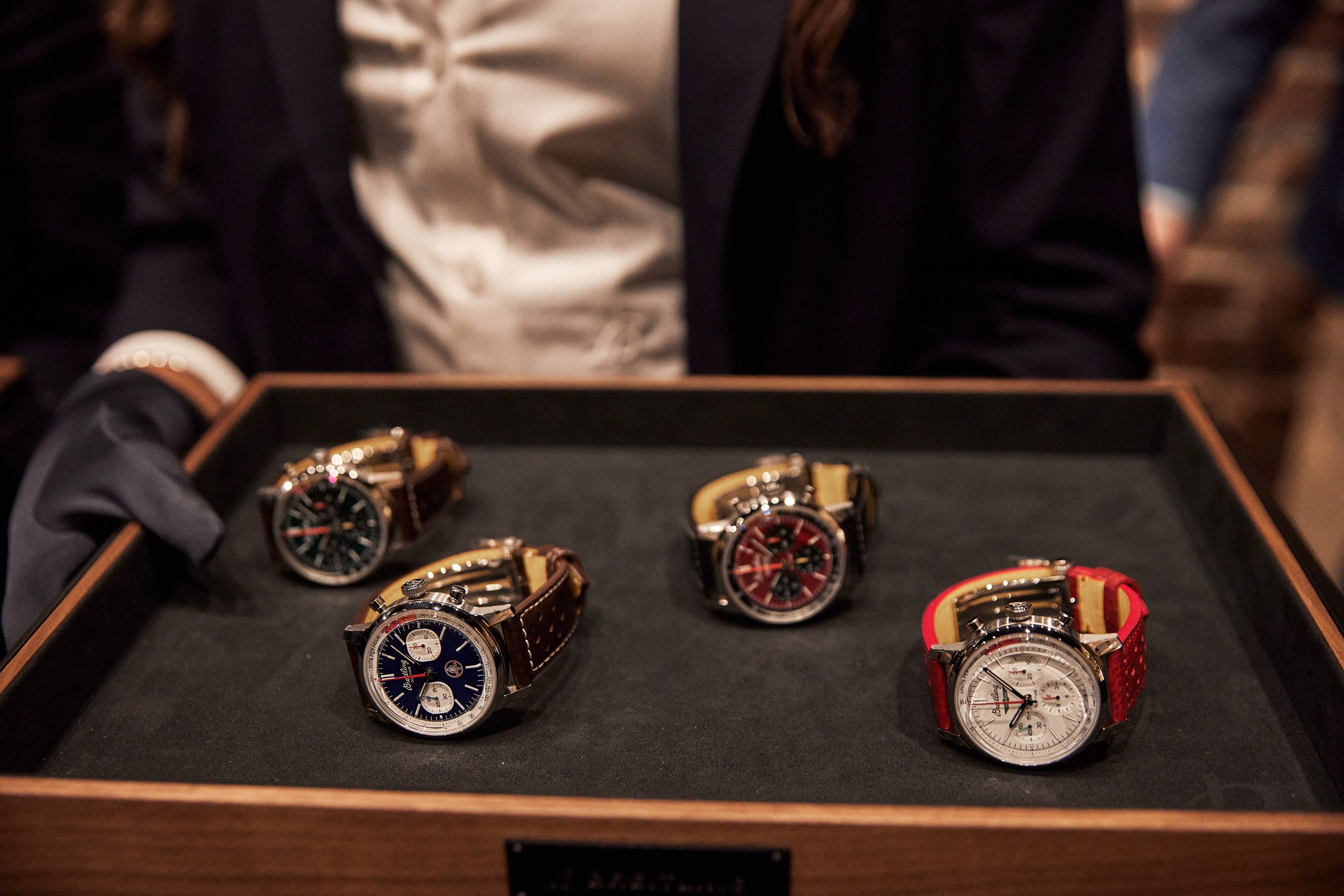 Bride sitting on ground against wall, groom standing nearby