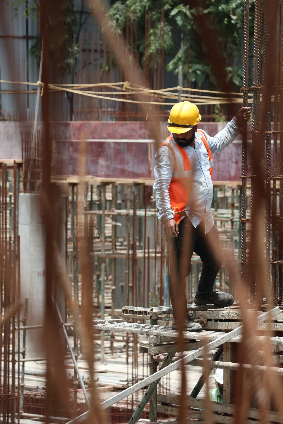 man in black jacket and yellow helmet holding black metal bar