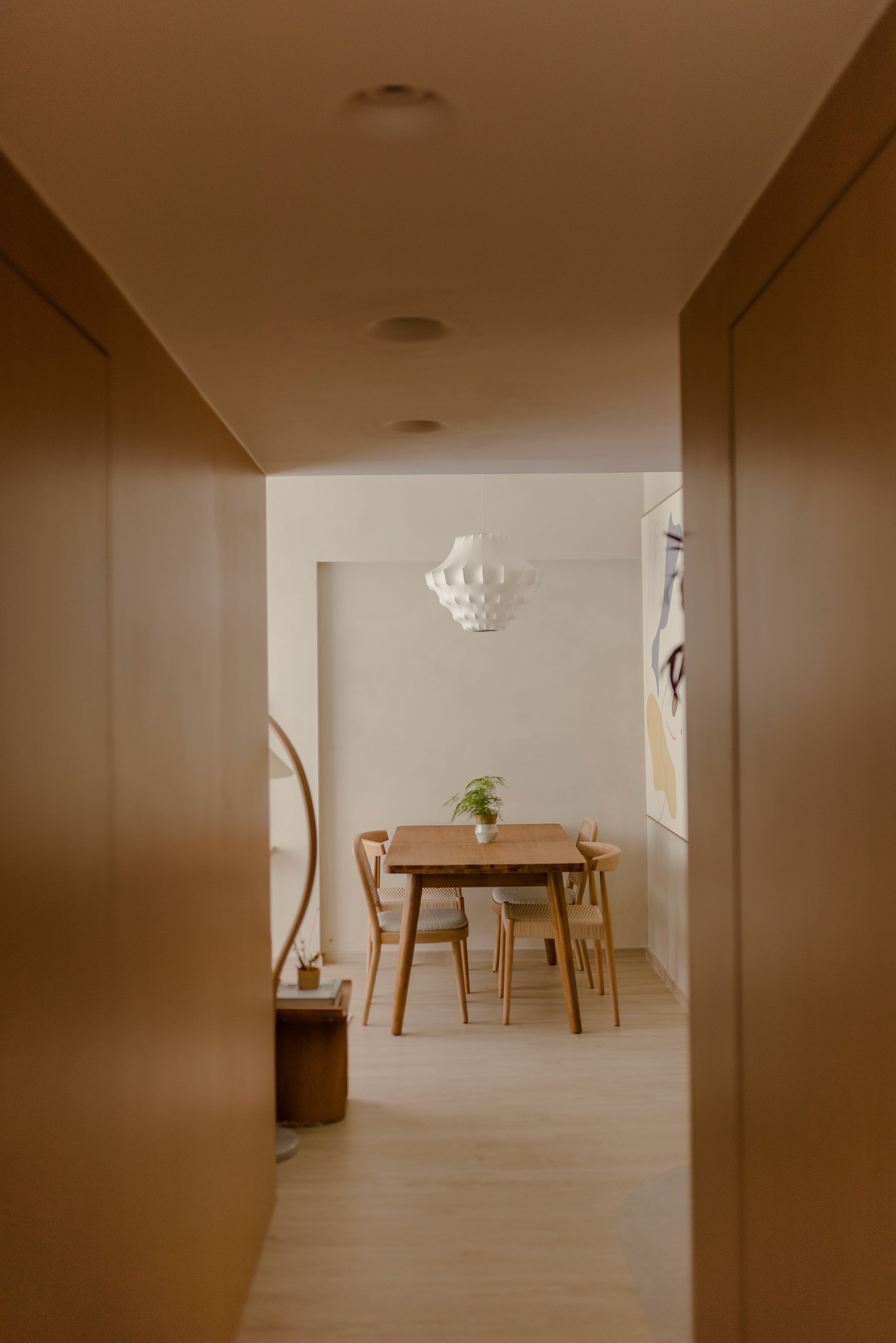 Scandinavian-style dining area in HDB flat with natural wood table and chairs, pendant lighting, and neutral palette by Persqft interior design