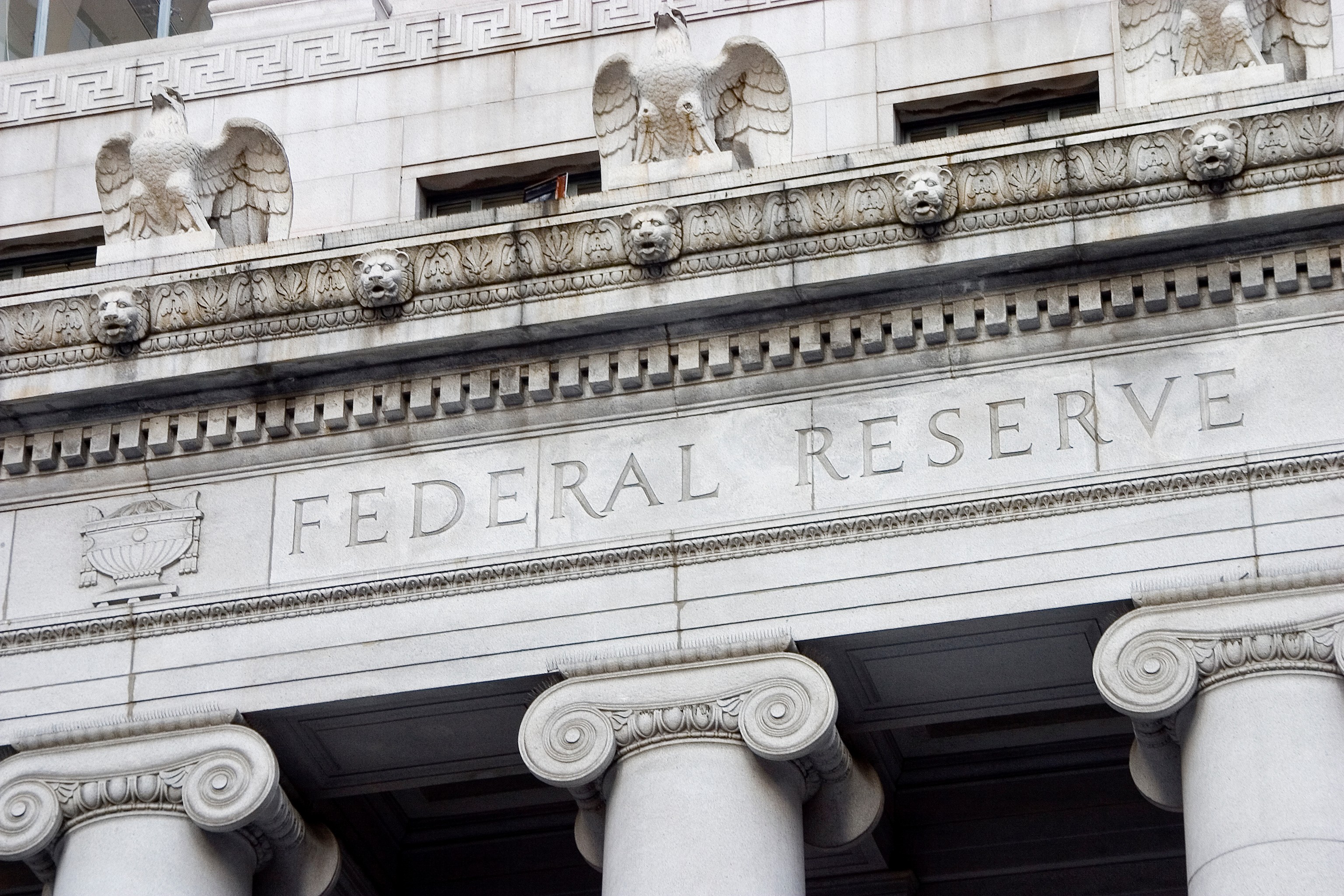 Exterior of the Federal Reserve building, showing stone columns, eagle sculptures and the words “Federal Reserve” carved into the façade.