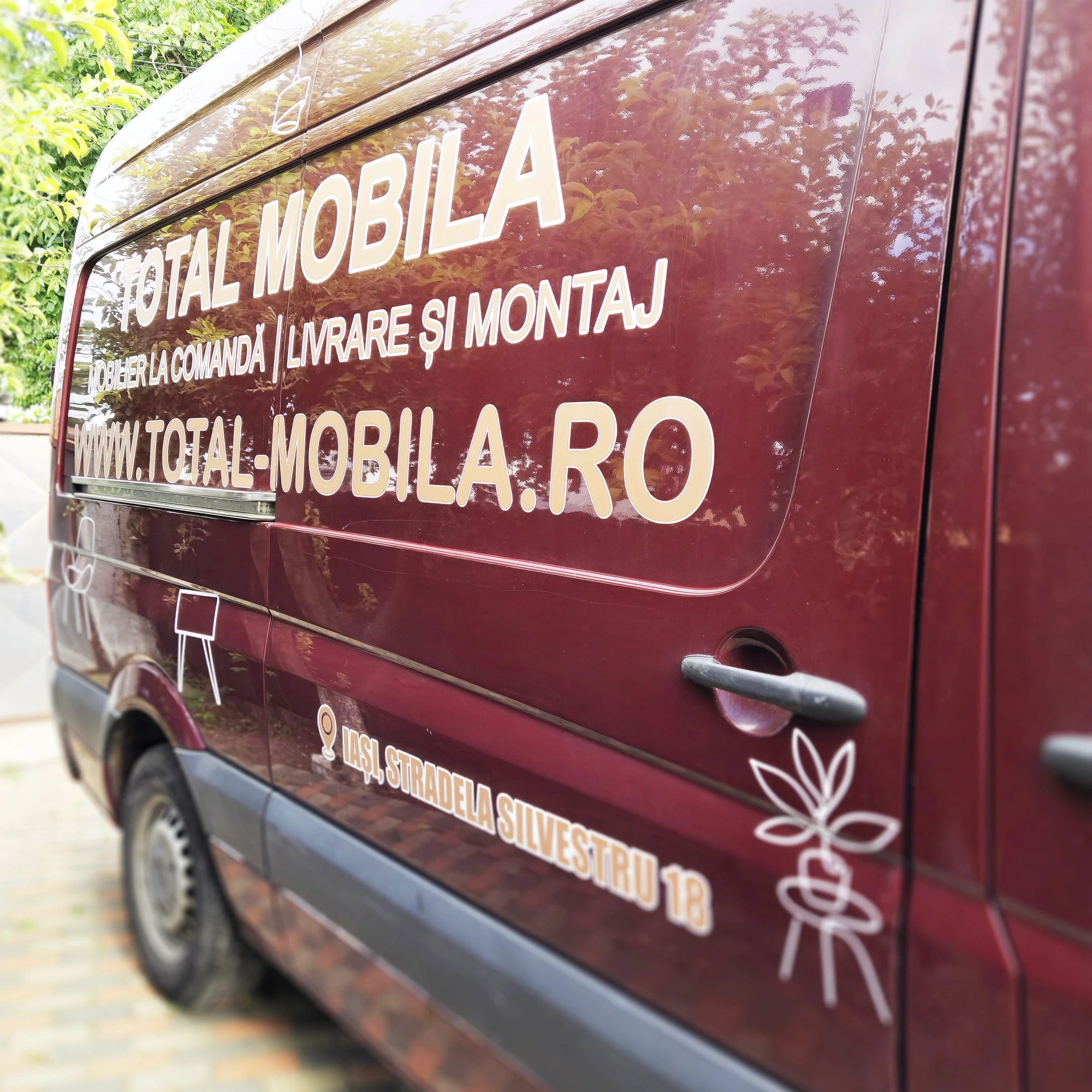 Detaliu ușă spate dubă Total Mobilă, adresă și iconițe colantate