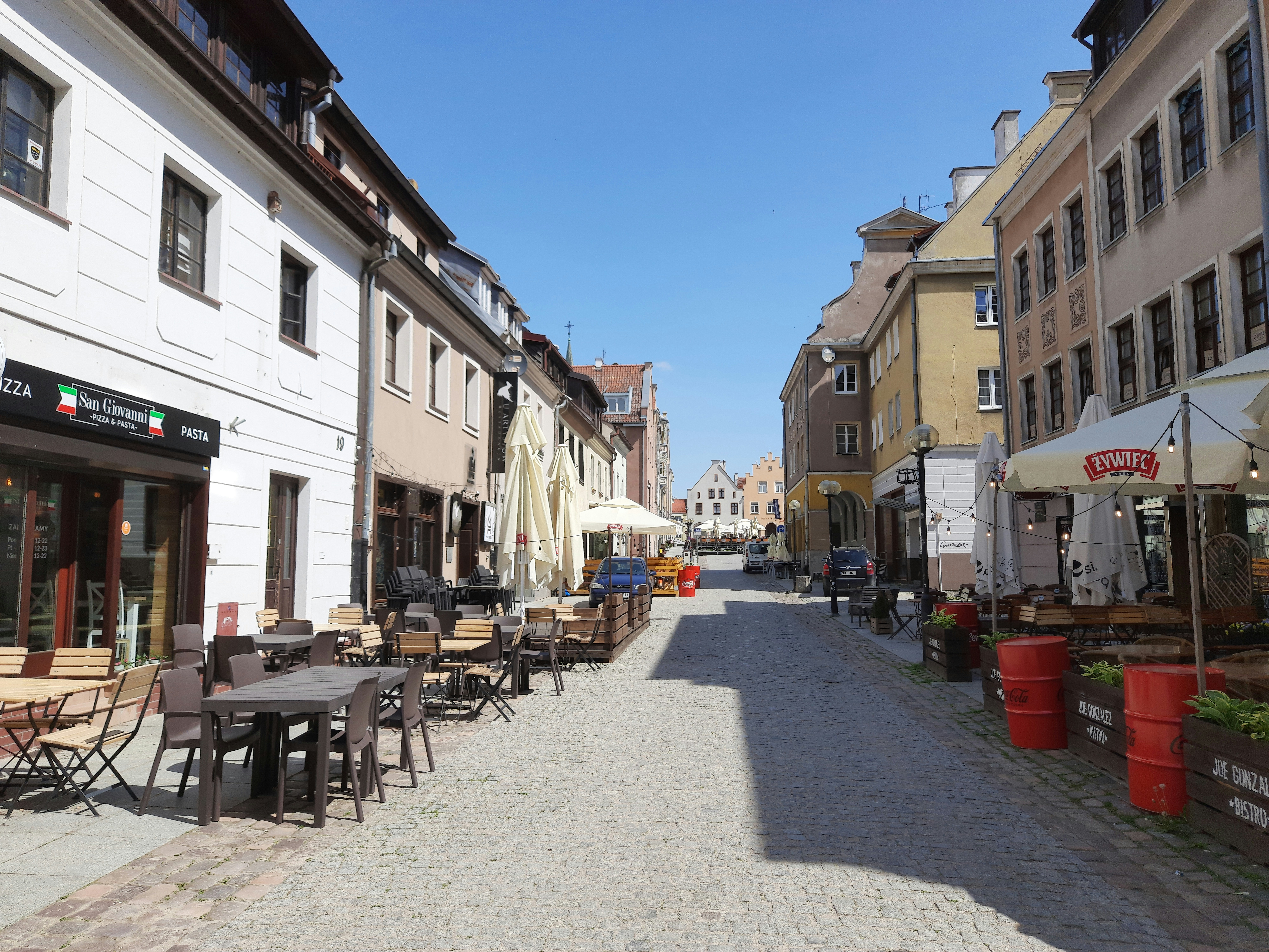 a cobblestone street lined with tables and chairs