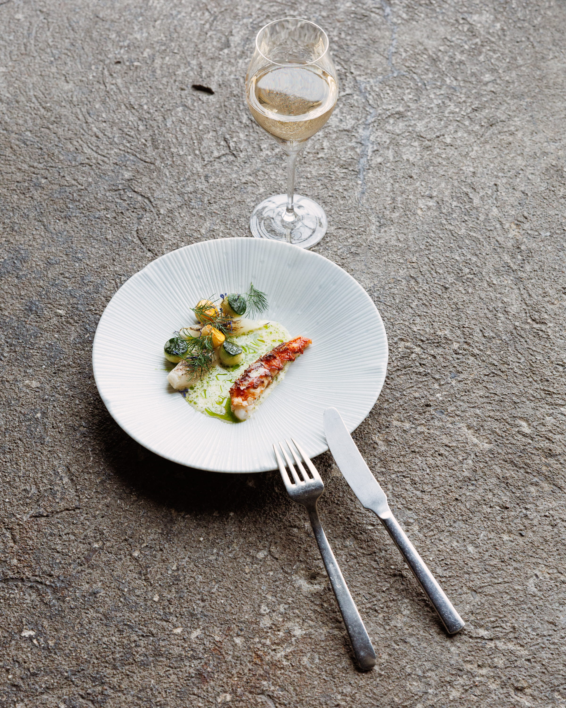 A gourmet dish and glass of wine on a table at Danesfield House Hotel