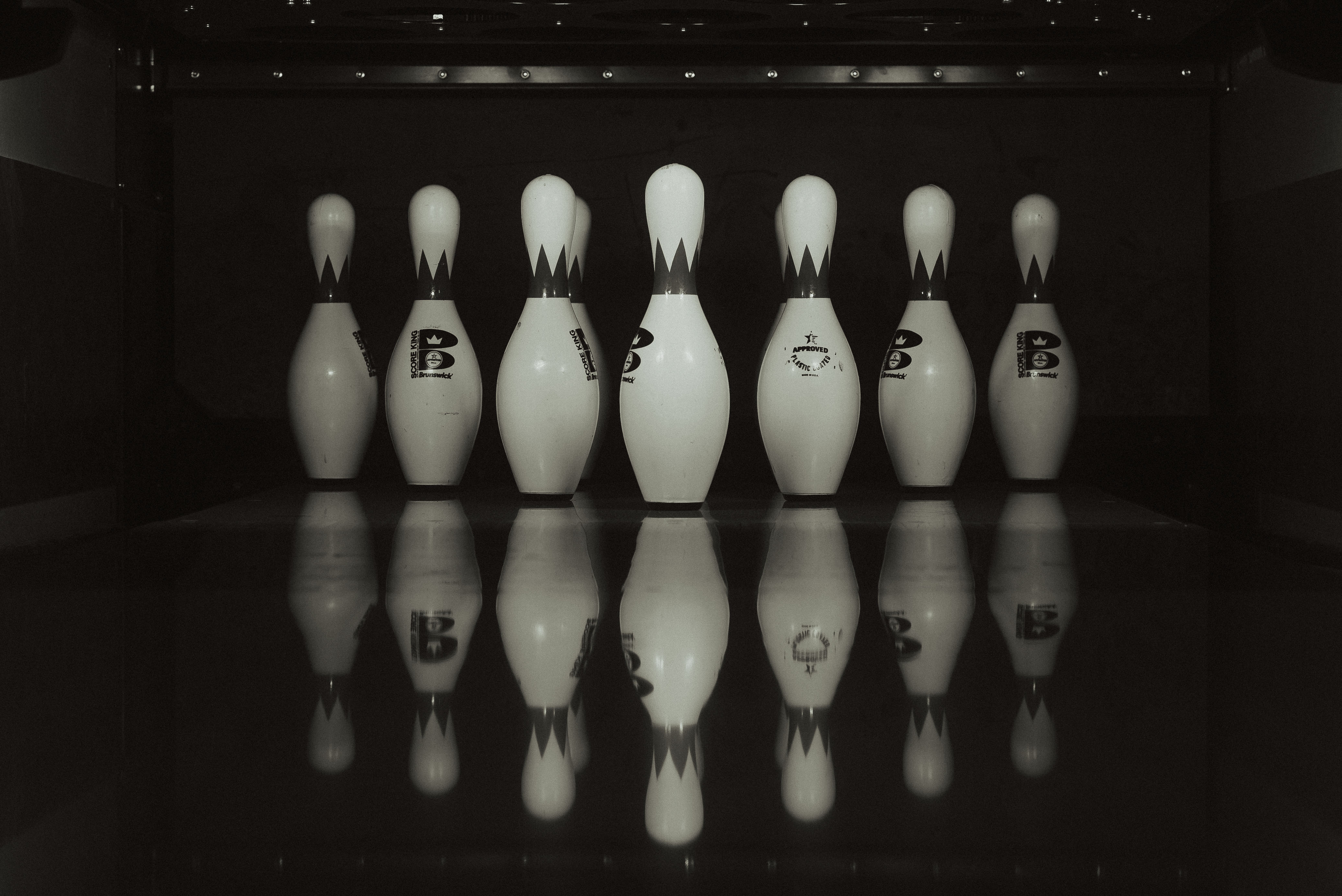 person holding bowling ball facing bowling pins