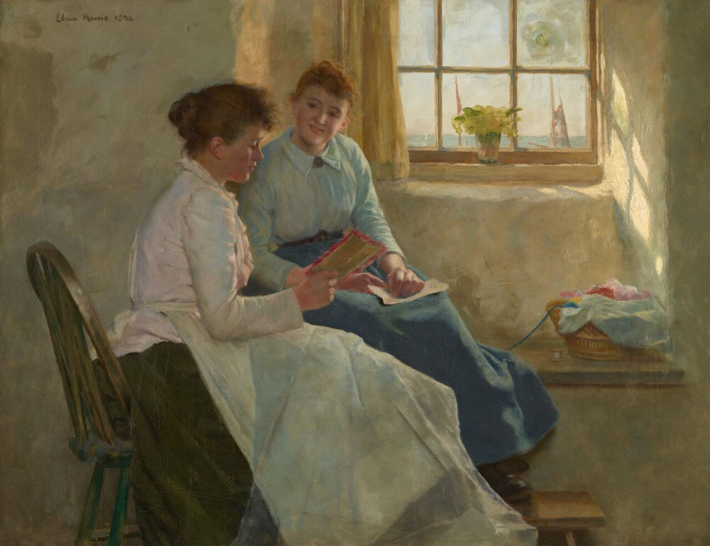 Two women sitting by a window, engaged in conversation, surrounded by a warmly lit interior.