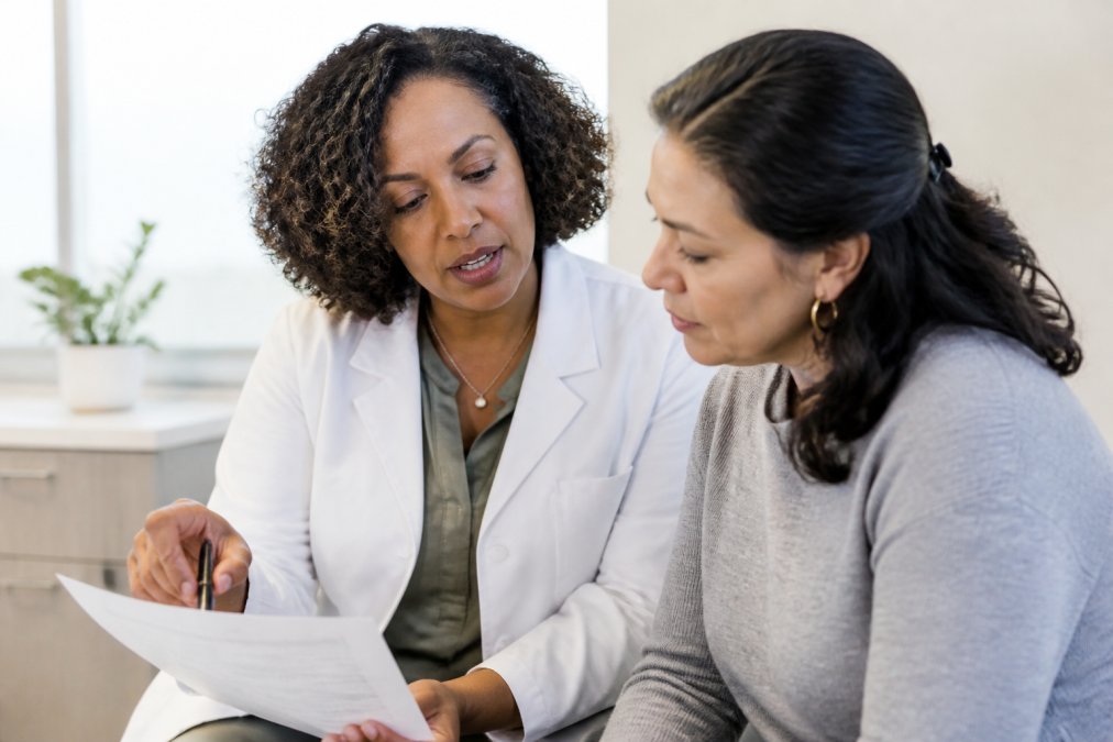 Healthcare provider reviewing personalized hormone plans with a patient in a bright clinical consultation room.
