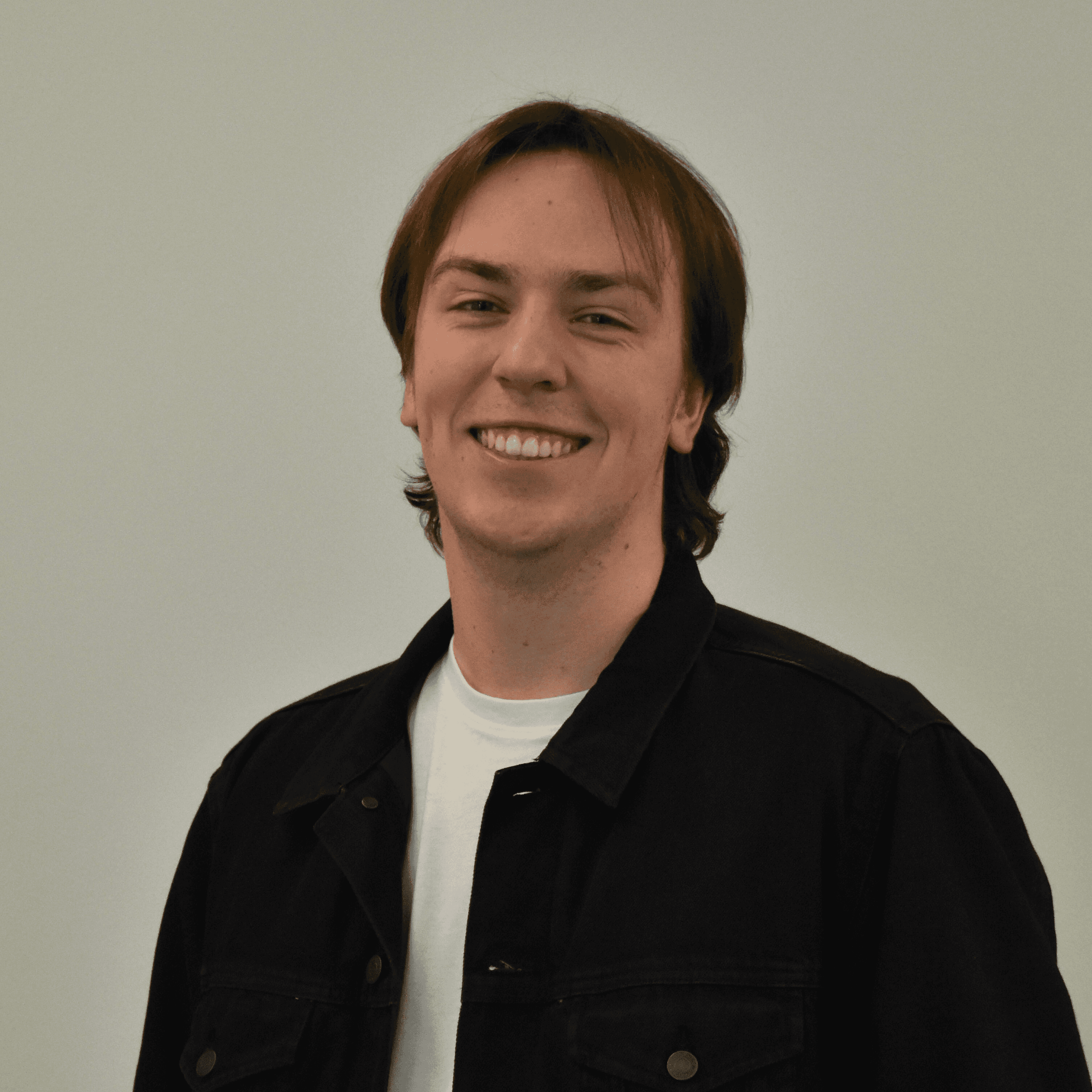 A thoughtful young person with dark hair gazes to the side, captured in soft black and white lighting.