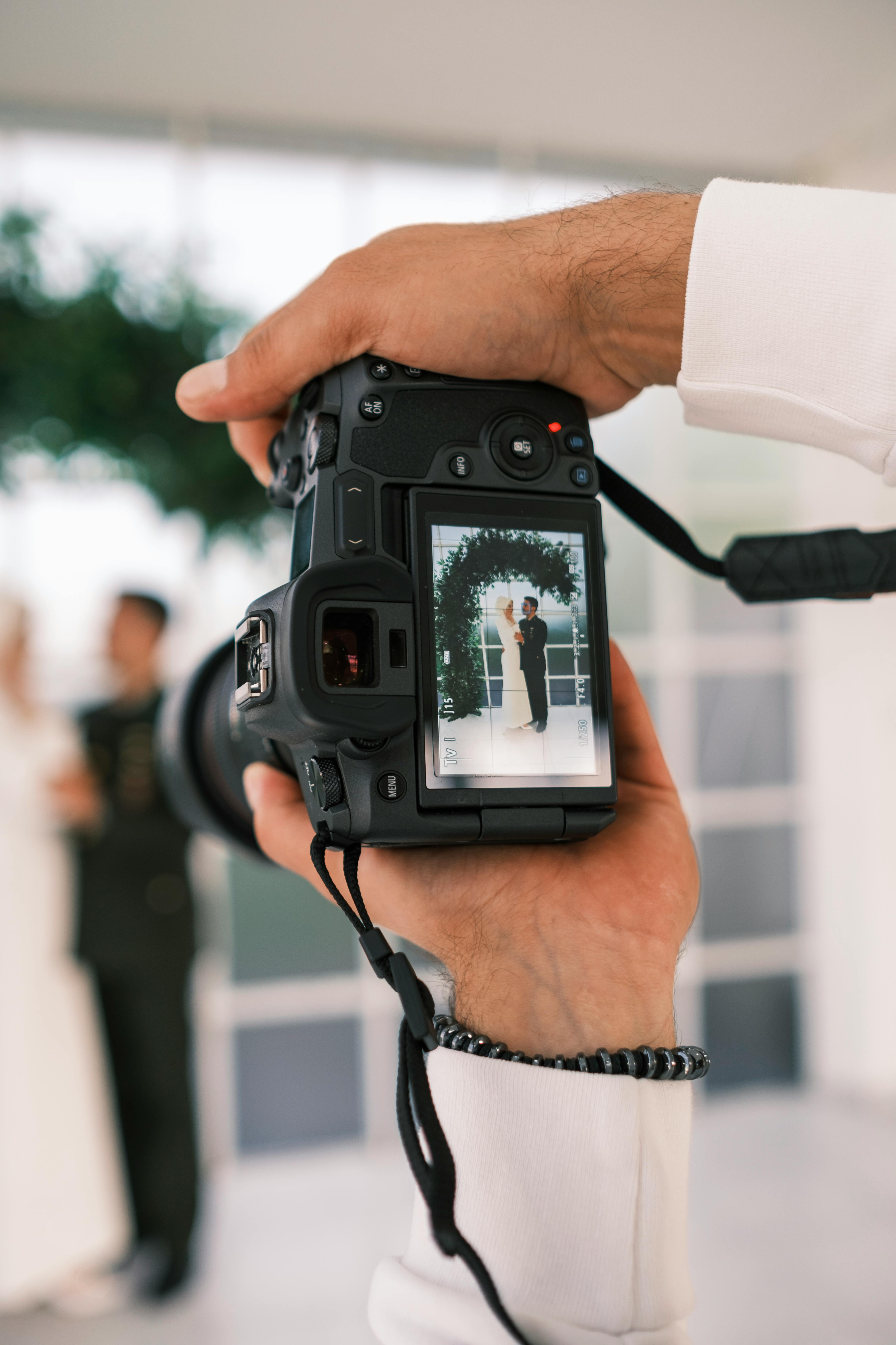 A person with short blonde hair holds a vintage camera.