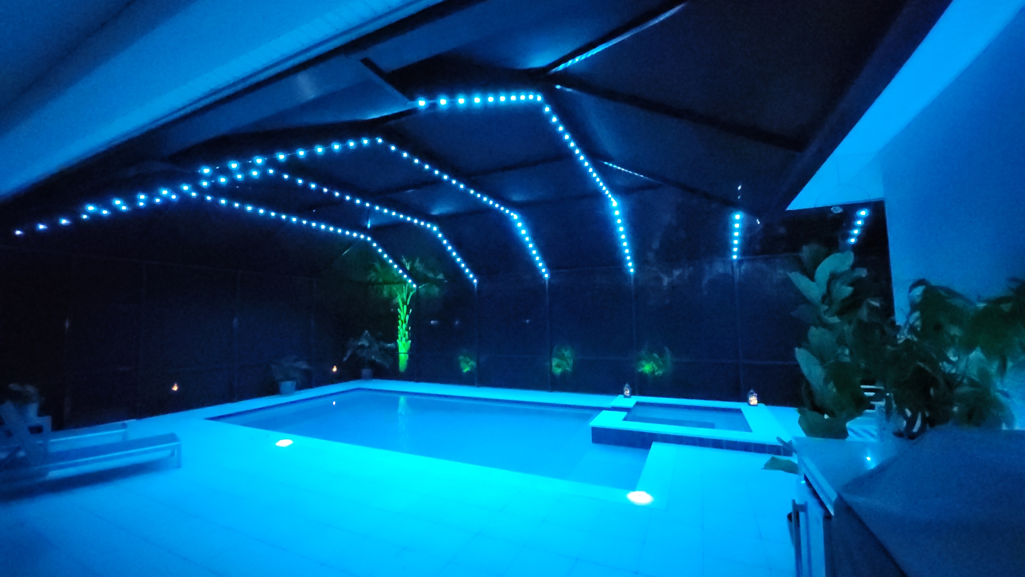 Modern pool cage lighting creating vibrant nighttime swimming atmosphere