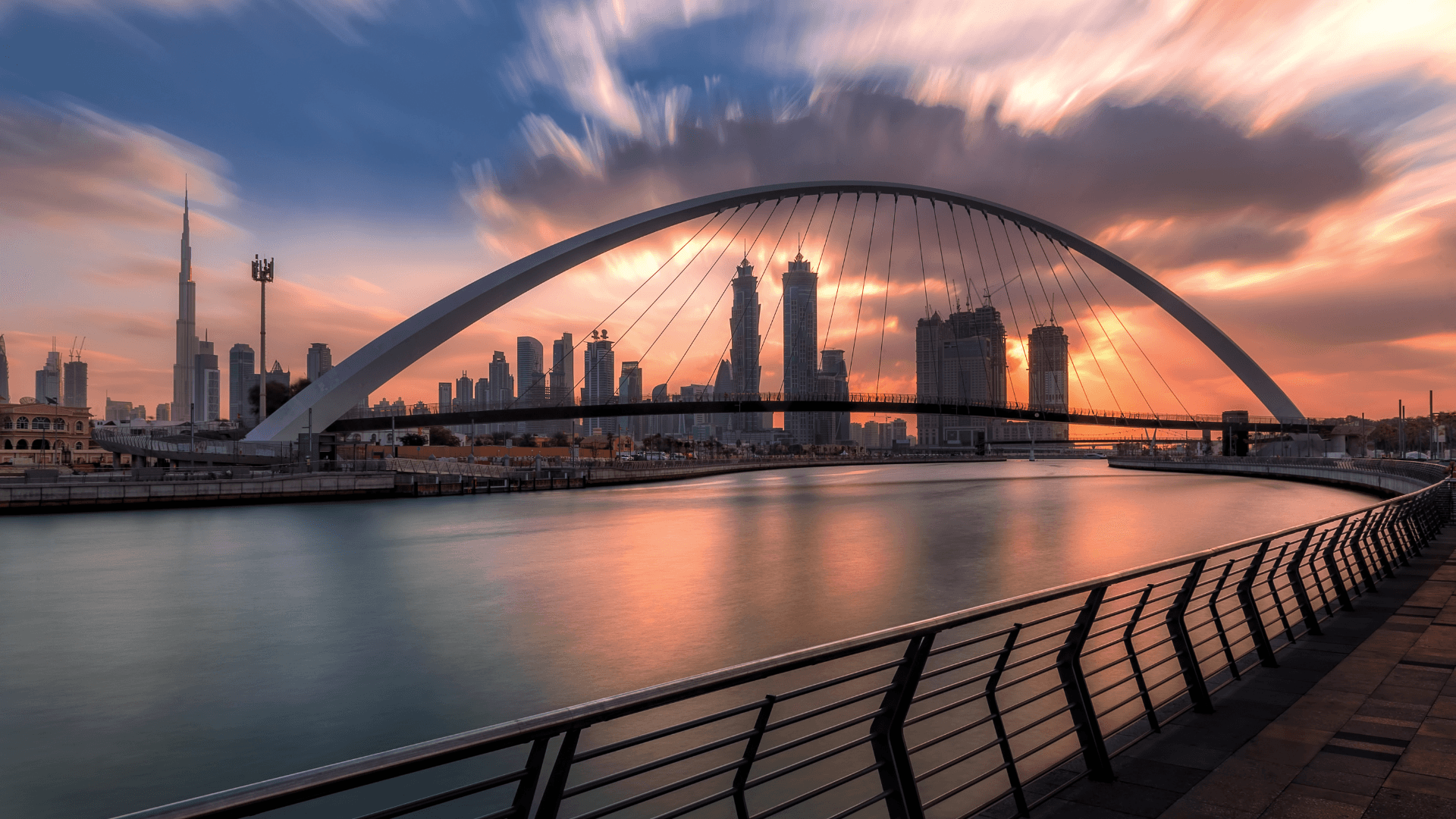 Sunset view of Dubai skyline with the Tolerance Bridge and Burj Khalifa reflecting on calm waters | Lunasole Hospitality