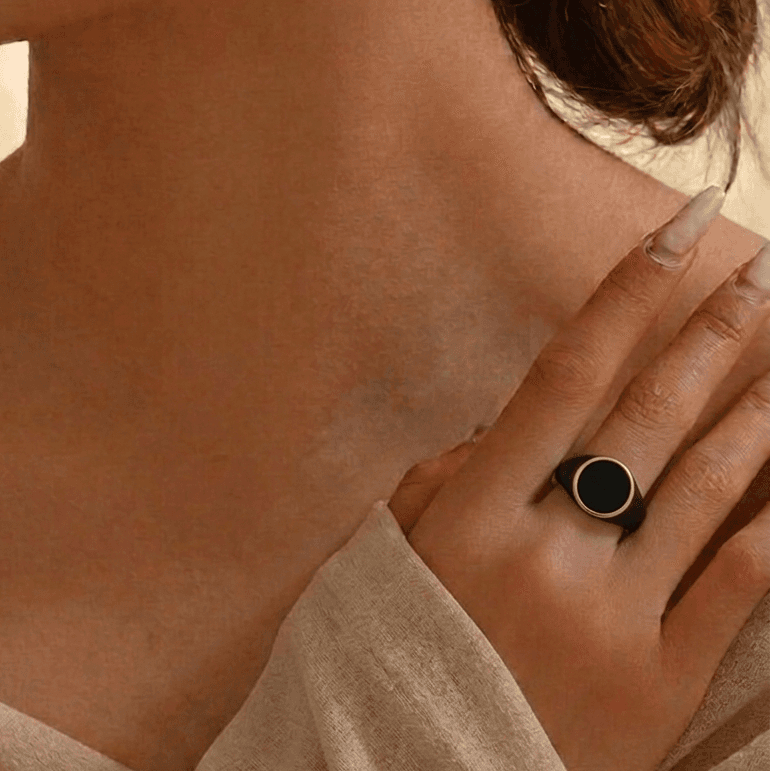 Close-up of a person wearing a ring on their hand with a soft focus background