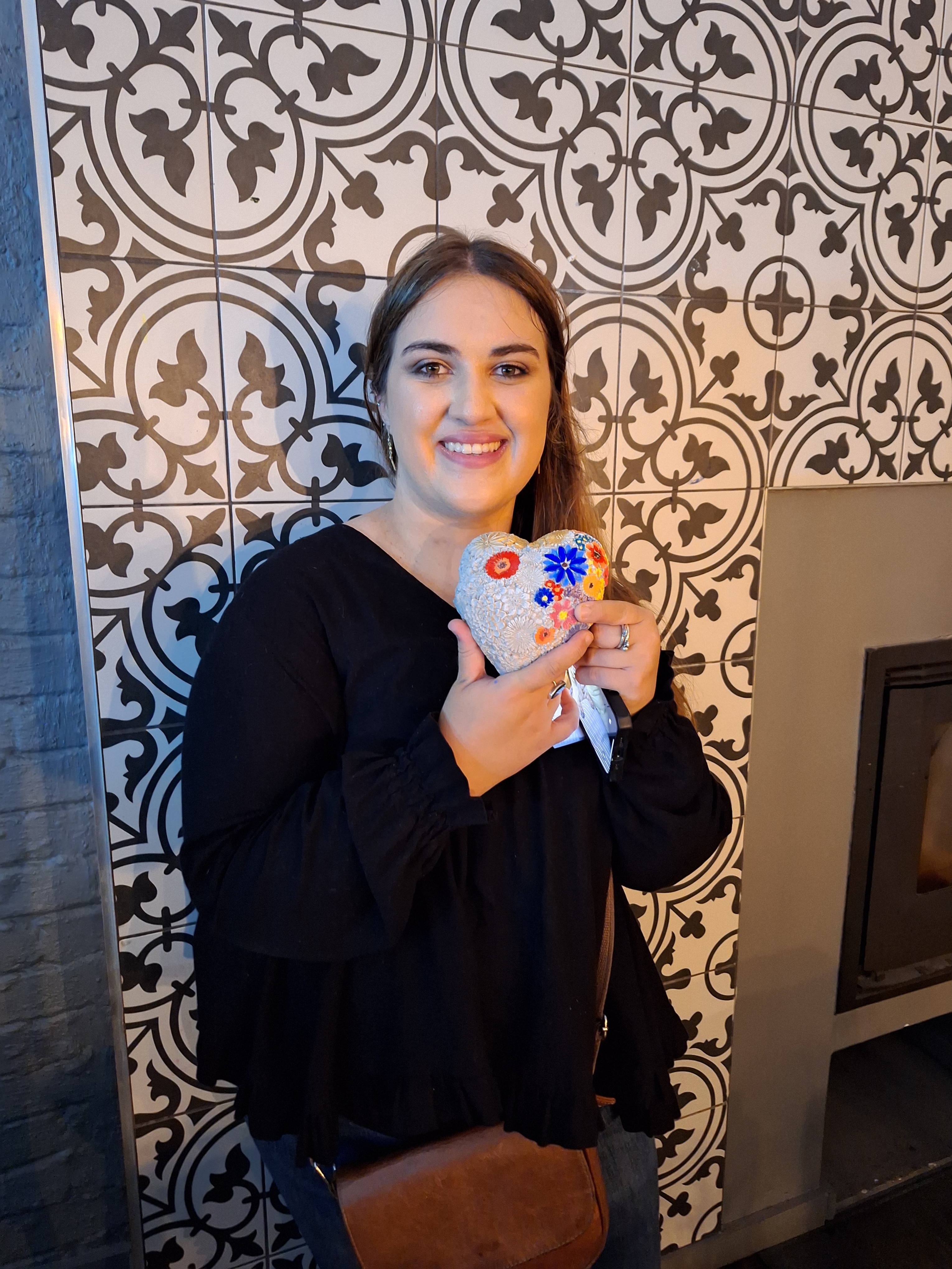 A girl smiling for a photo with painted artwork