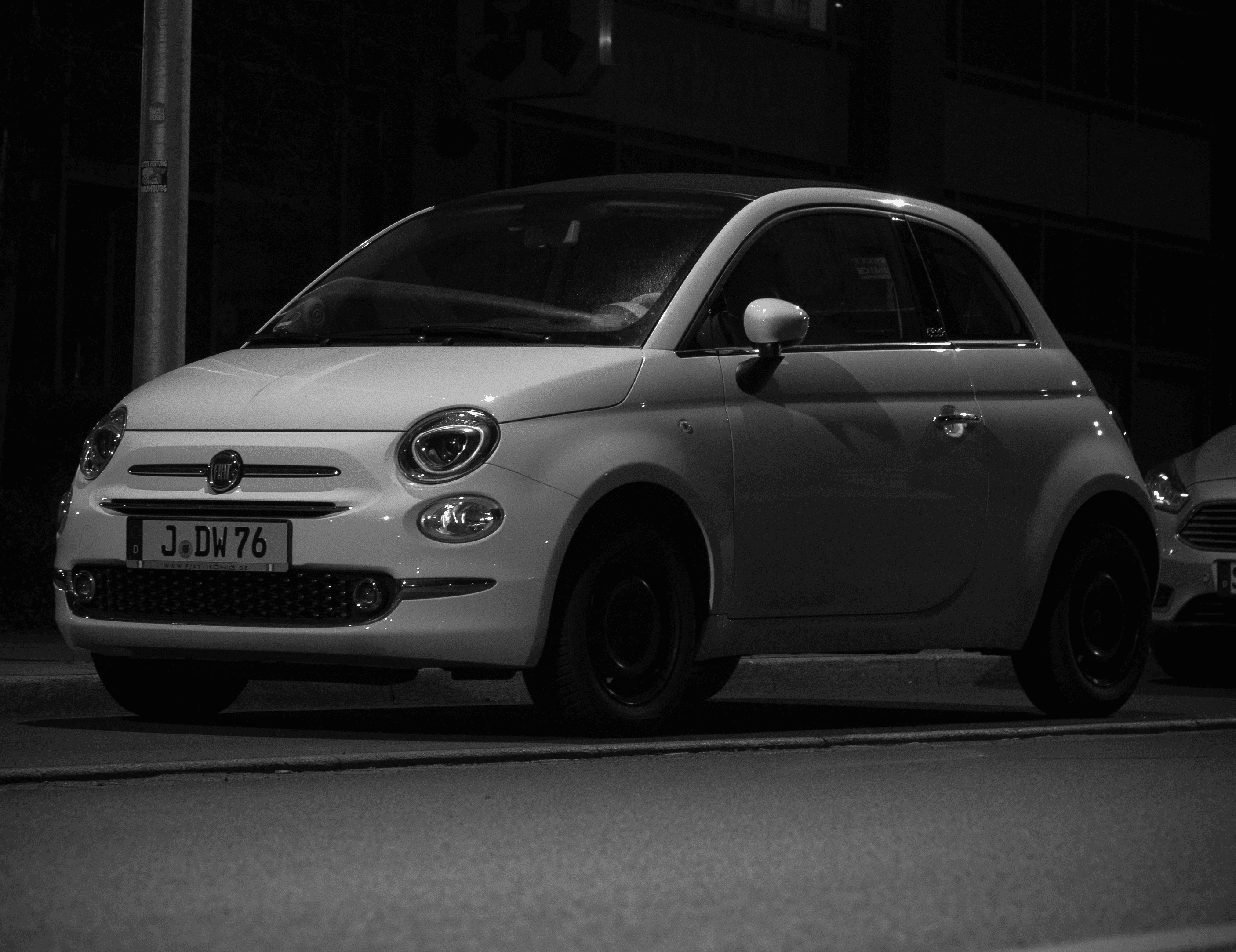 a small white car parked on the side of the road