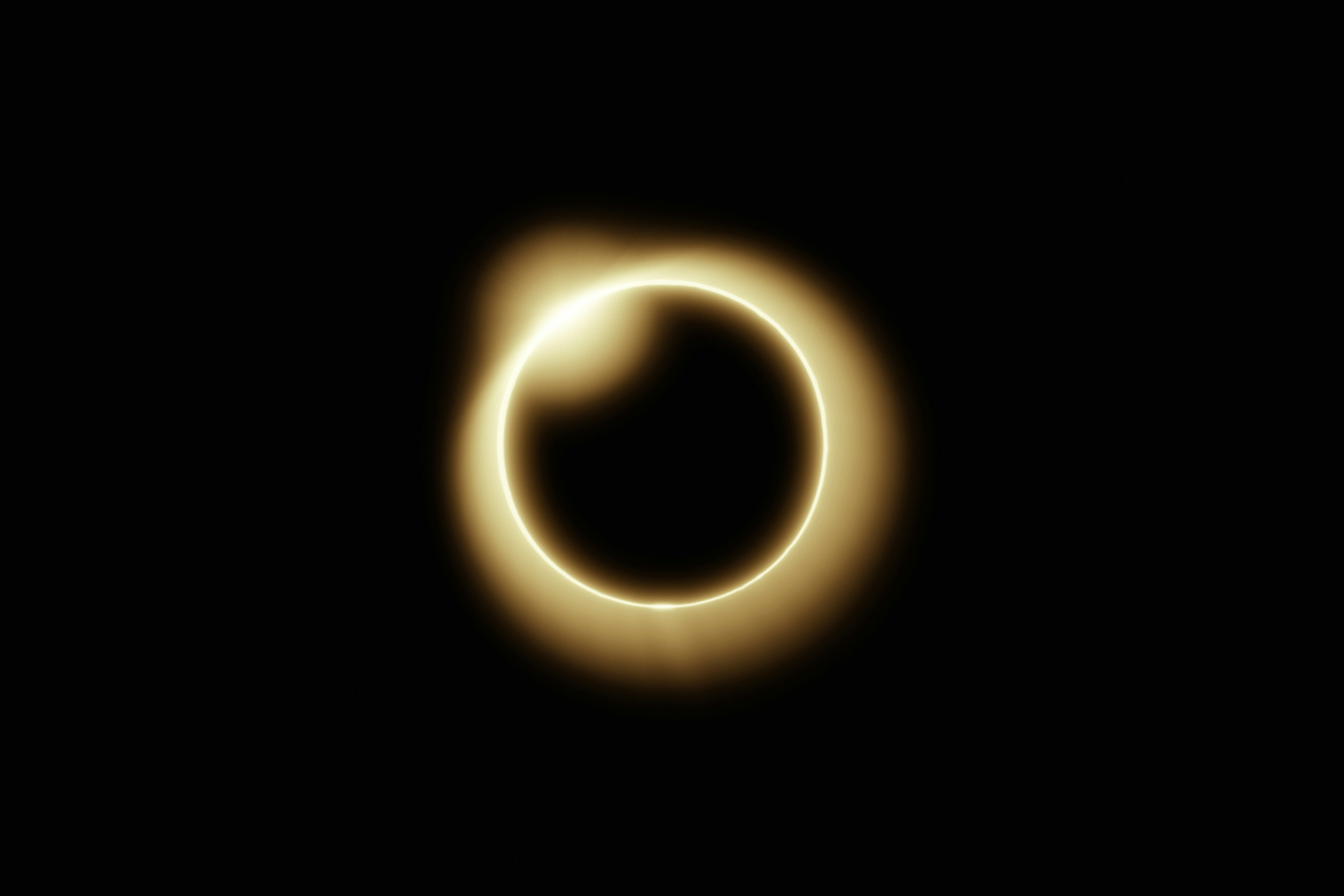 A glowing ring surrounds a dark circle in blackness.
